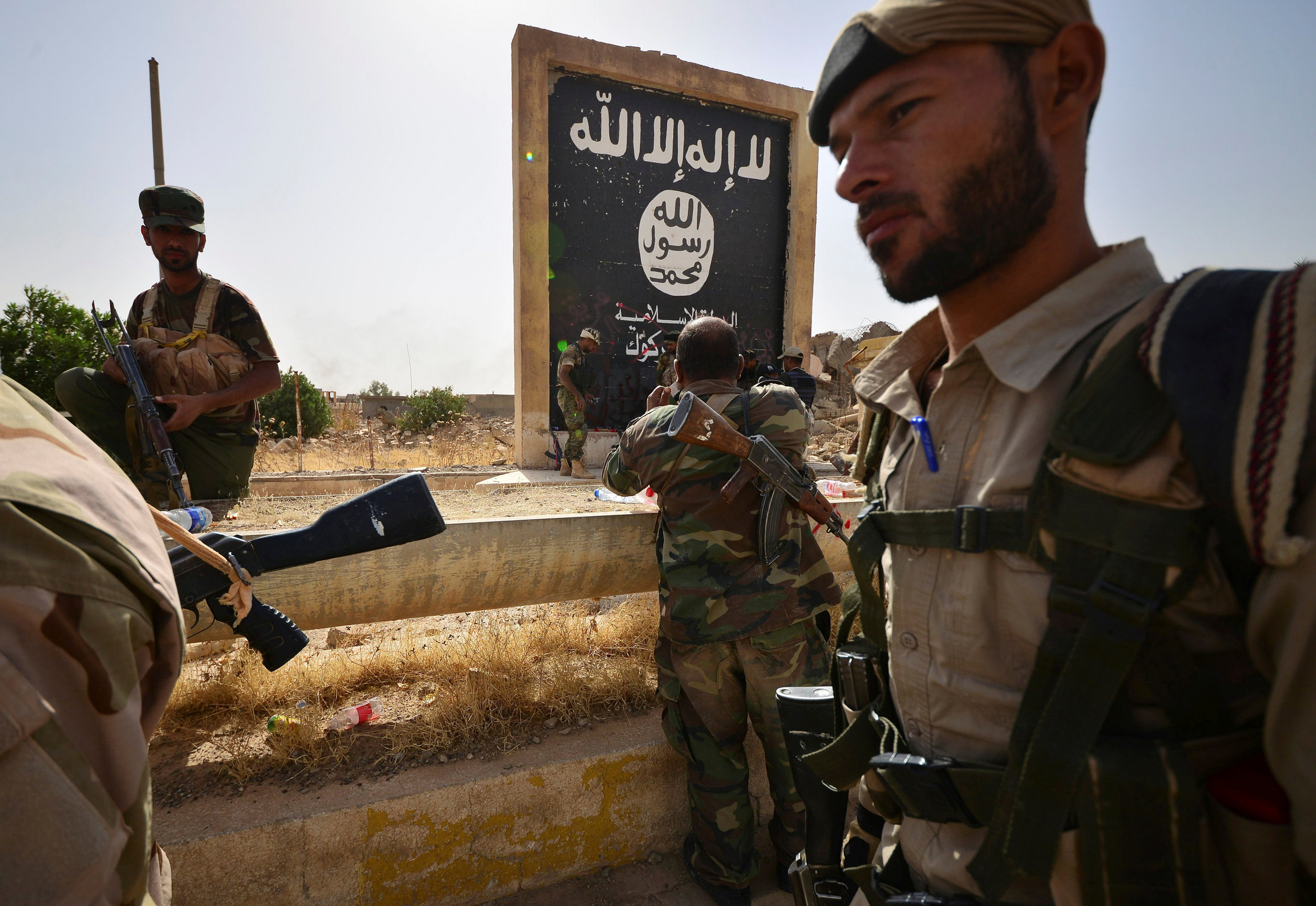 القوات العراقية أمام لافتة للتنظيم الإرهابى فى الحويجة