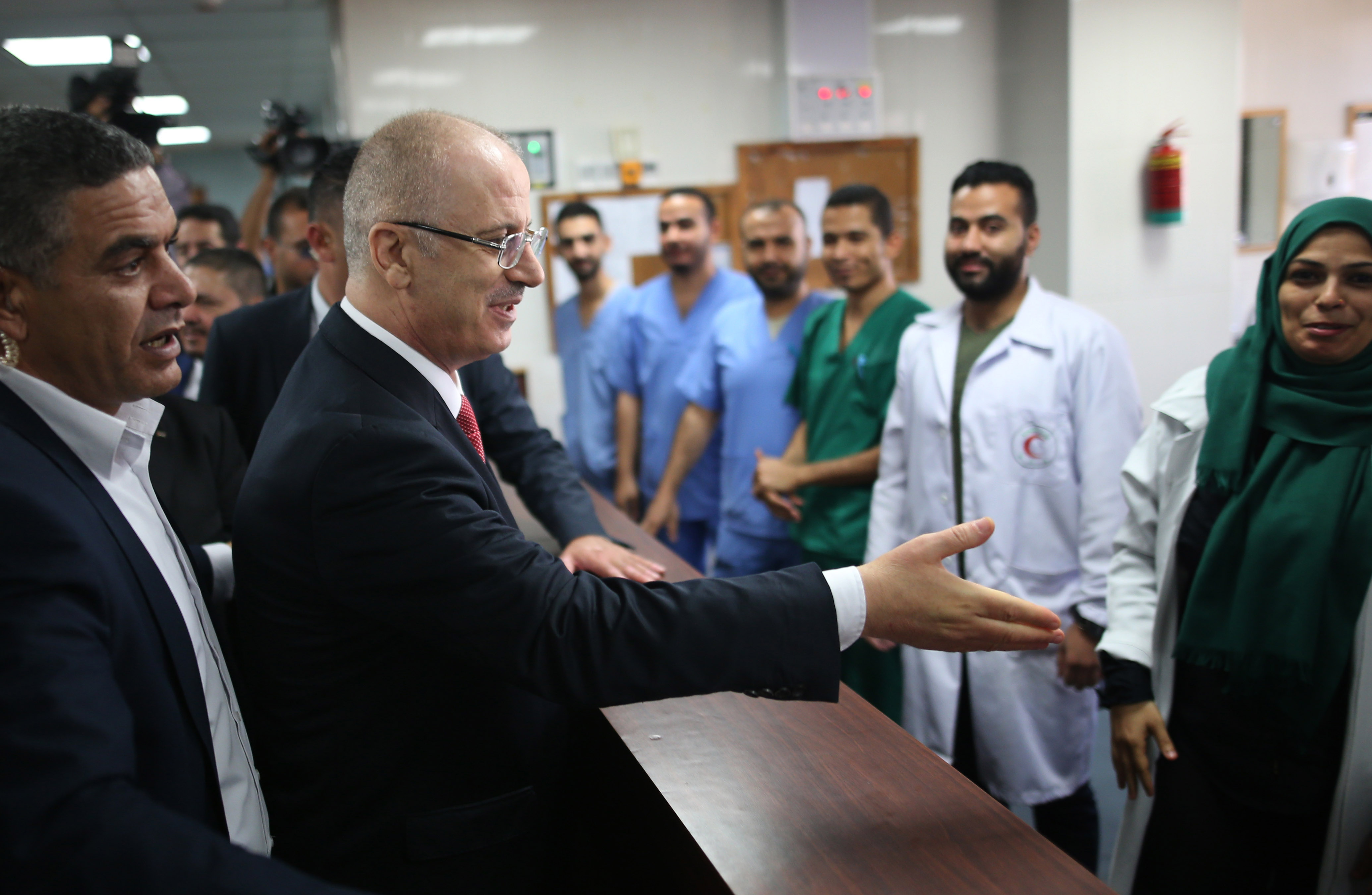 رئيس الوزراء الفلسطينى يصافح العاملين فى مستشفى بغزة