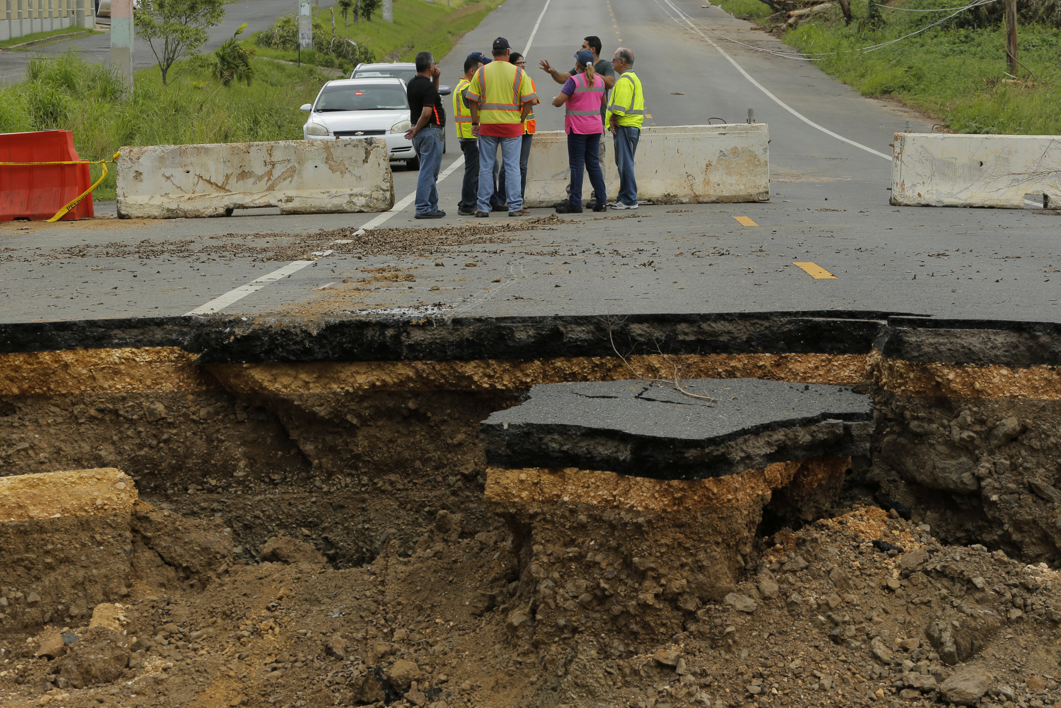 المهندسون يحاولون إصلاح الطريق بعد انهيار جزء منه جراء الإعصار