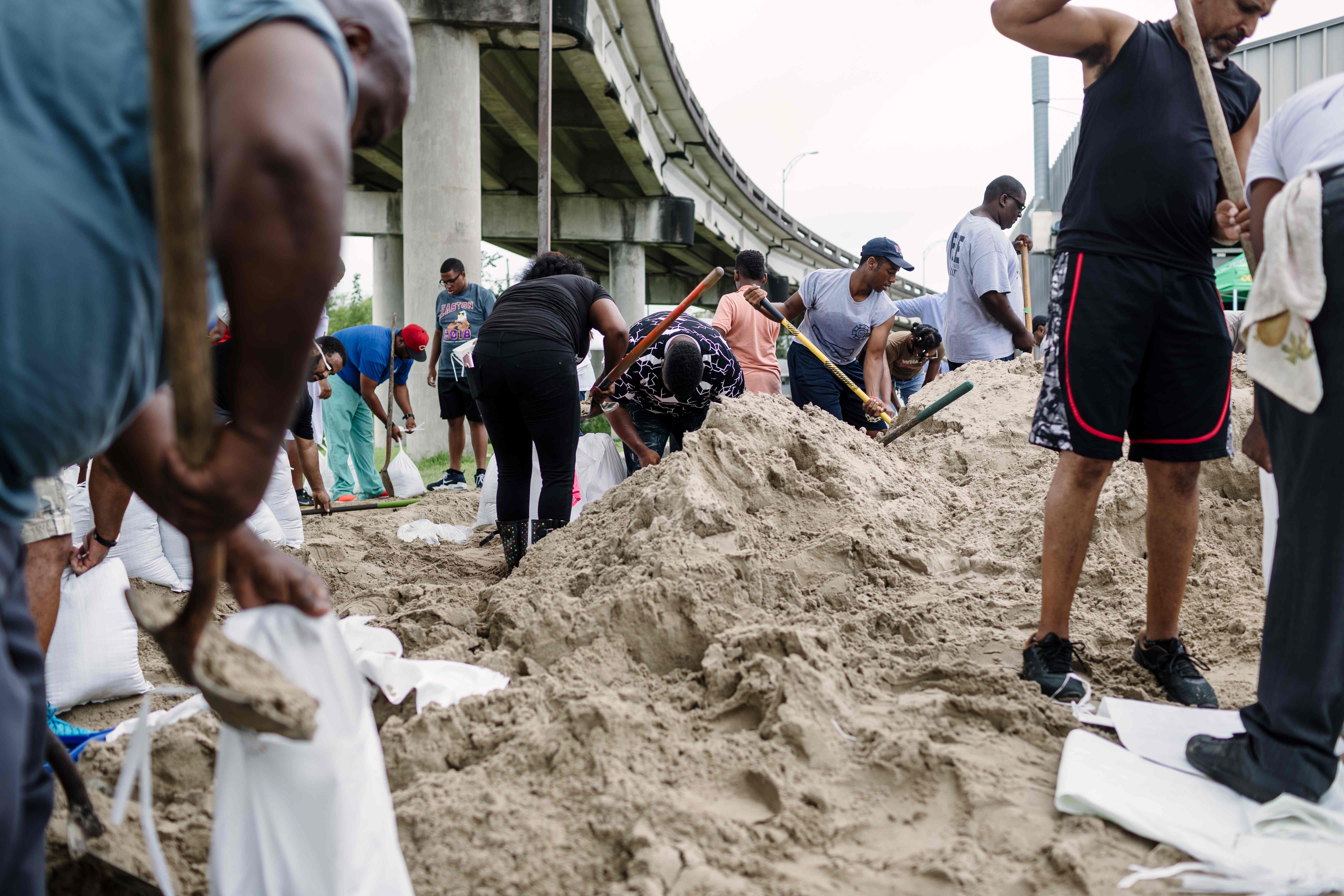 المواطنون يتشاركون تجميع الرمال لحماية المنازل من الغرق