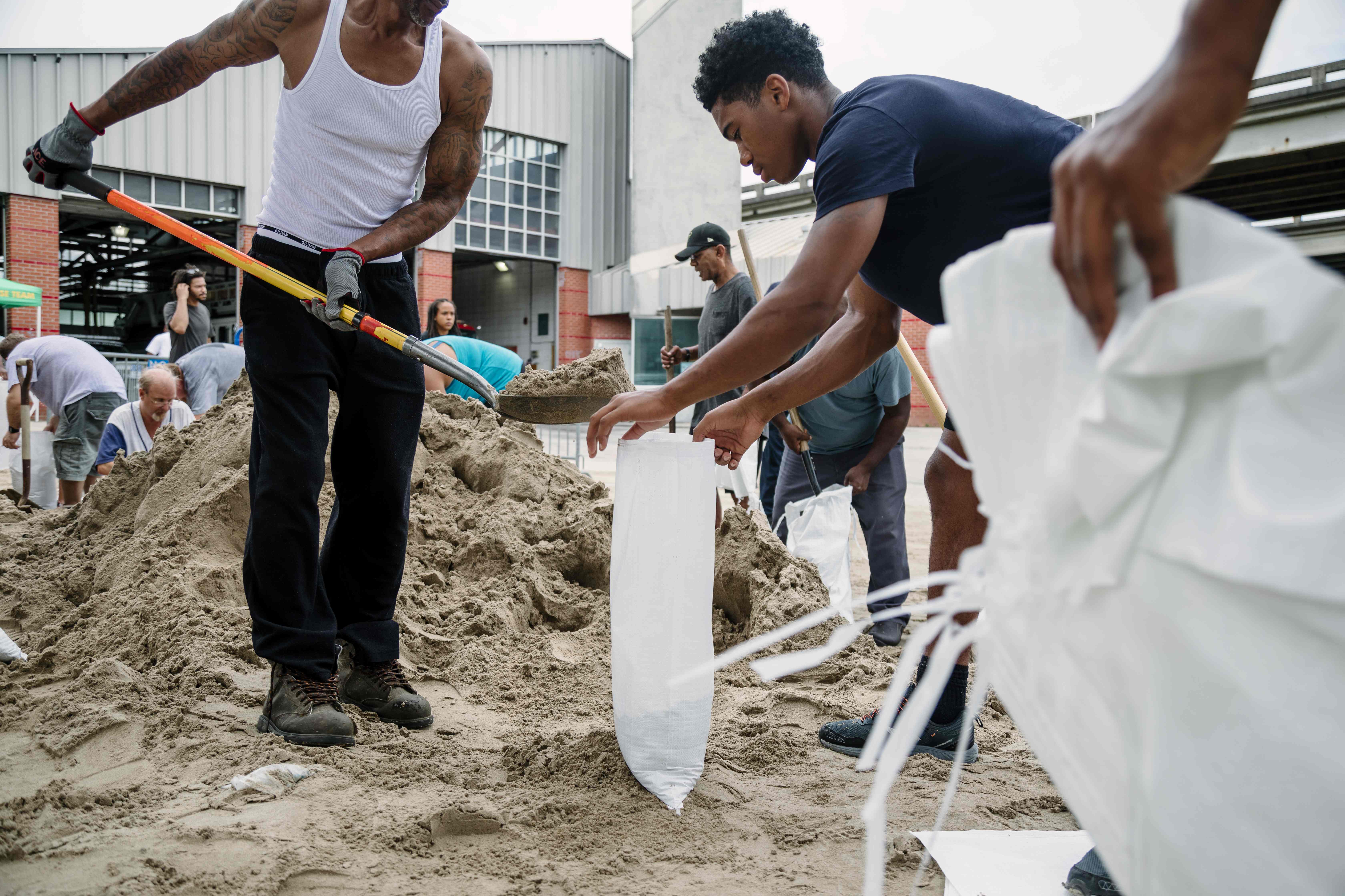 شاب يحمل الرمال لحماية المنازل من الغرق بسبب اعصار نايت