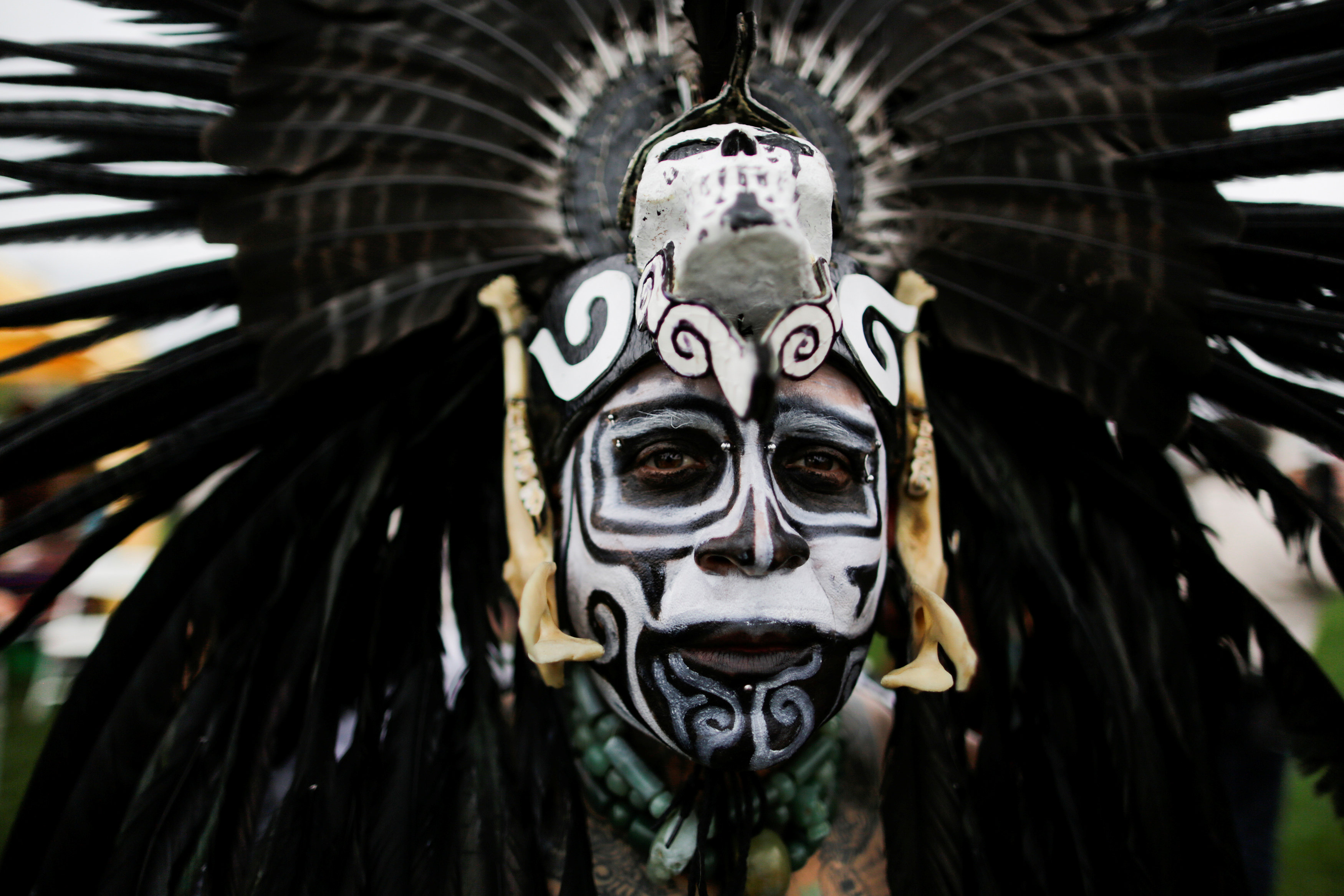 رجل يلون وجهه بقناع يجسد أجداده من السكان الأصليين لأمريكا