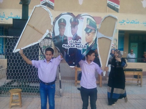 الطلاب يحملون صور شهداء حادث استاد كفر الشيخ