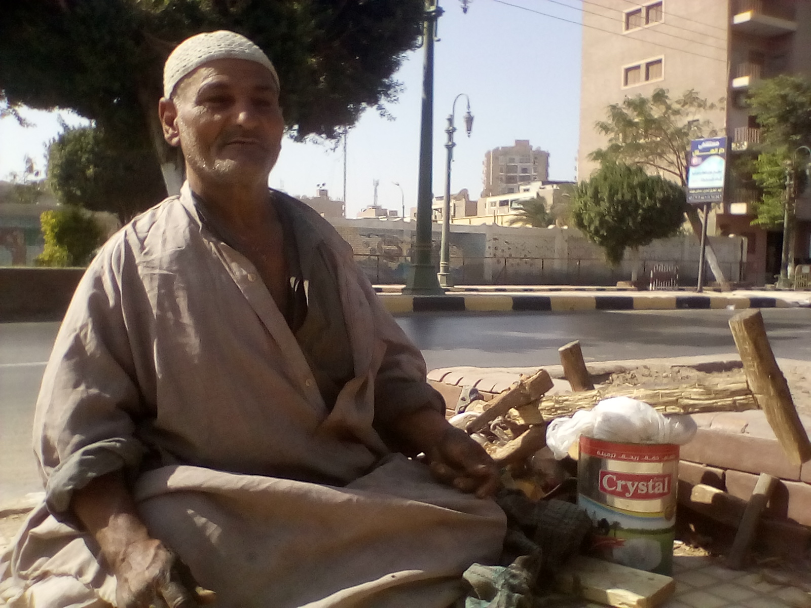 محمد يجلس على الرصيف بين متعلقاته