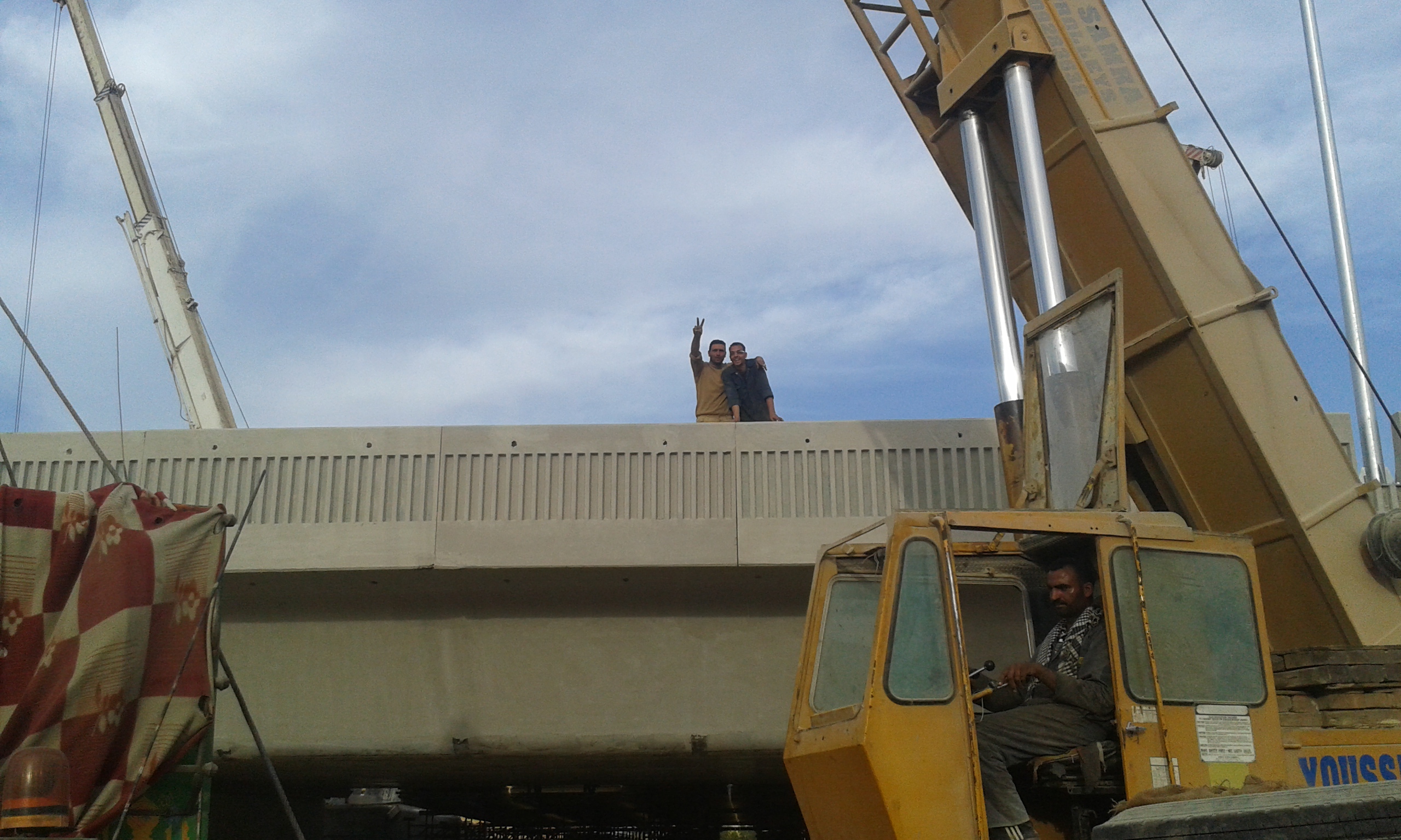 العمال يشيرون بعلامة النصر لمصور اليوم السابع