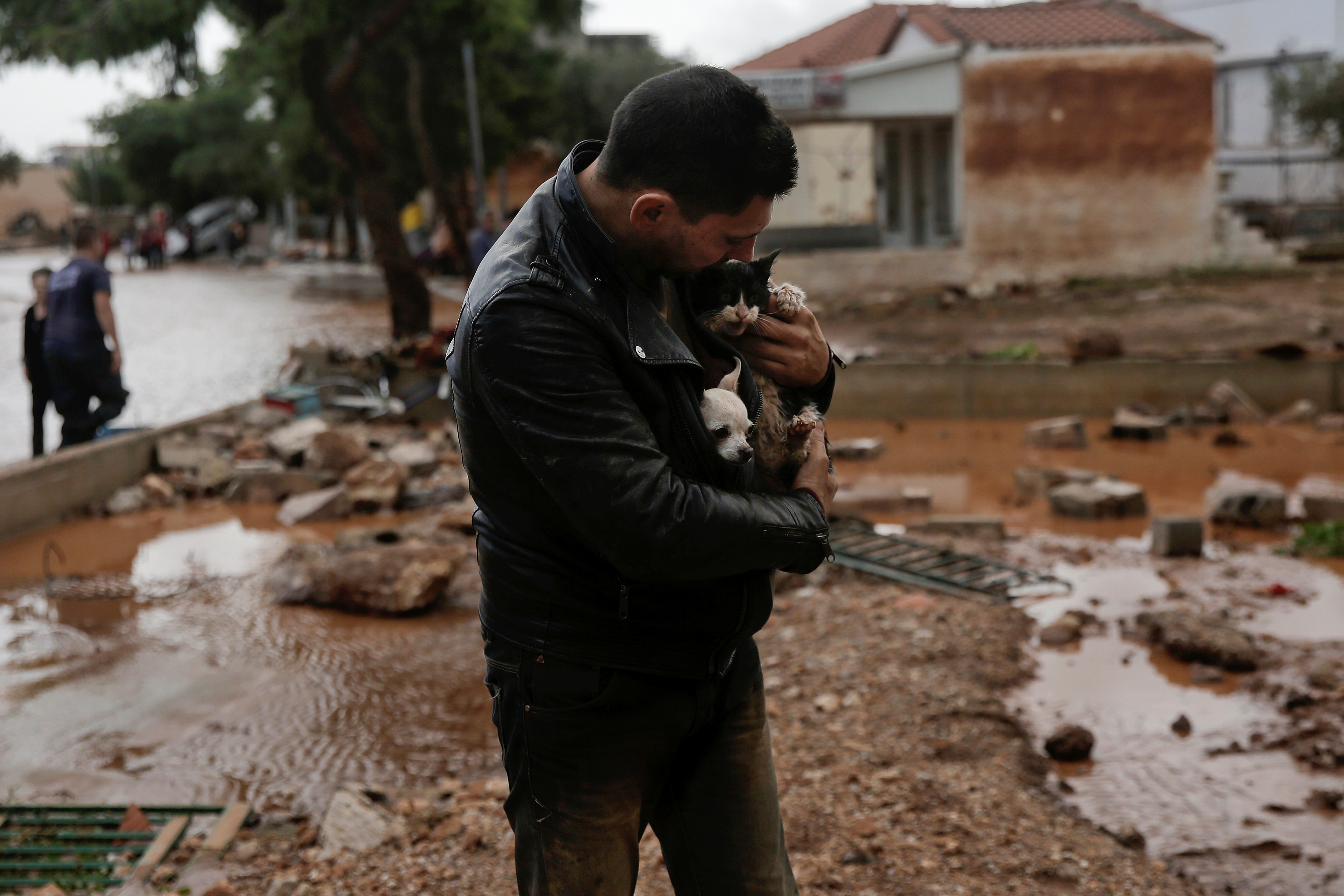 مواطن يحتضن قطته خوفا من مياة الأمطار