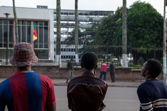 مواطنون يصطفون أمام مبنى البرلمان الكاميرونى بعد إطفاء الحريق