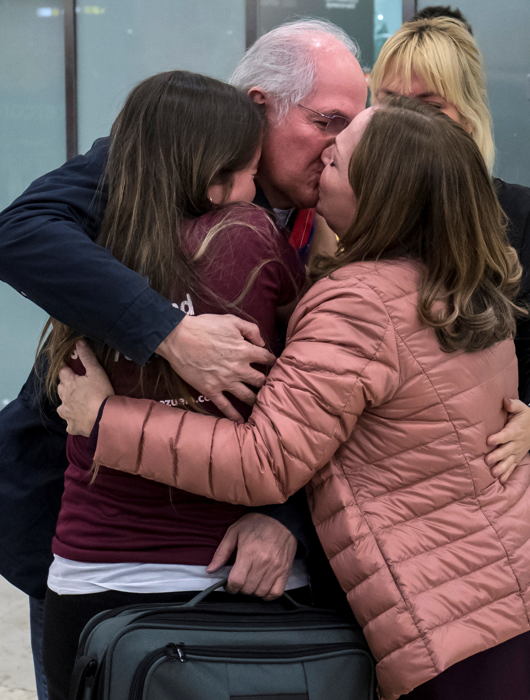 زعيم المعارضة الفنزويلية يقبل زوجته وابنته فور وصوله مدريد