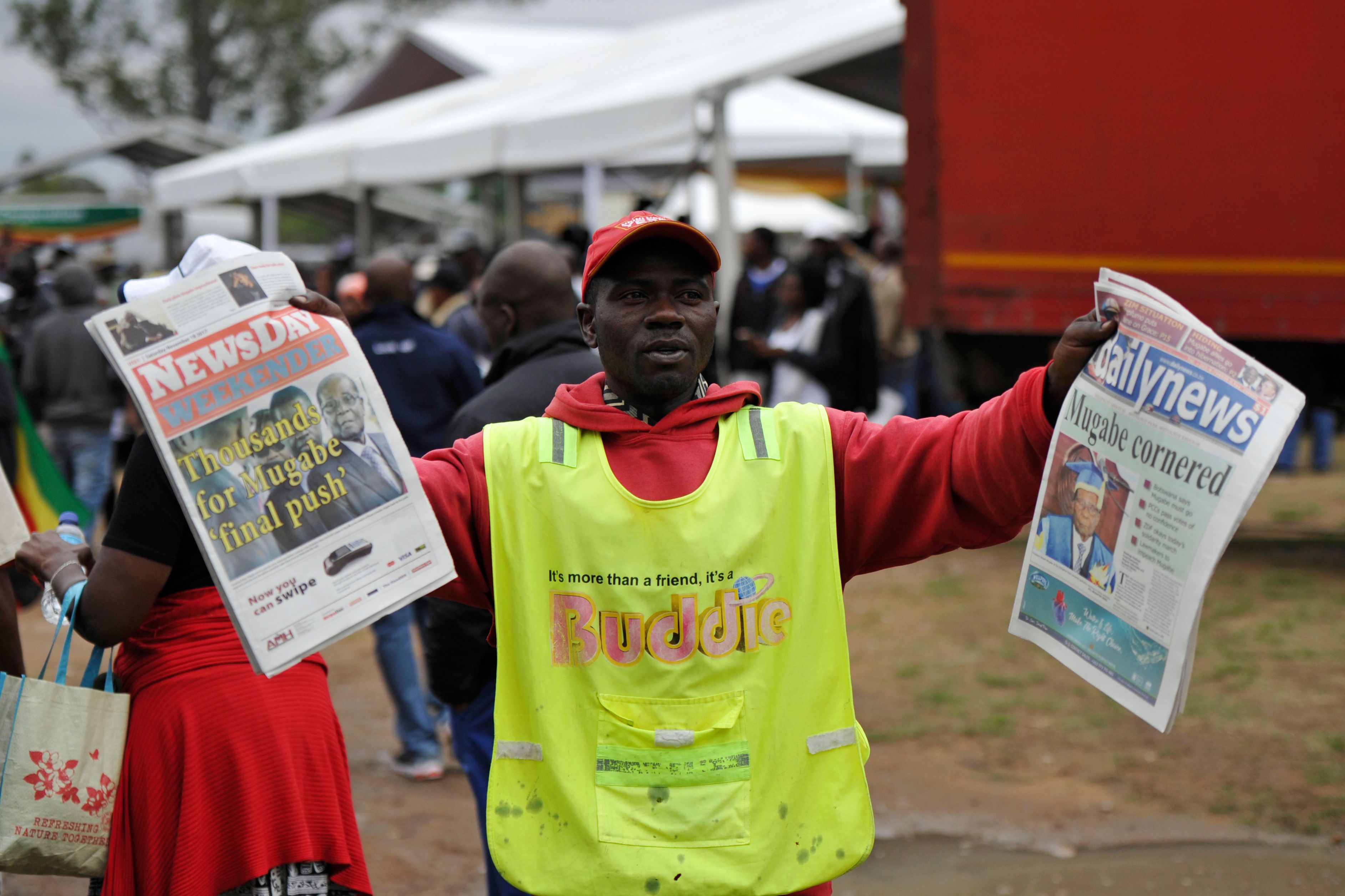 متظاهر يحمل الصحف المتناولة تفاصيل الأزمة السياسية فى زيمبابوى