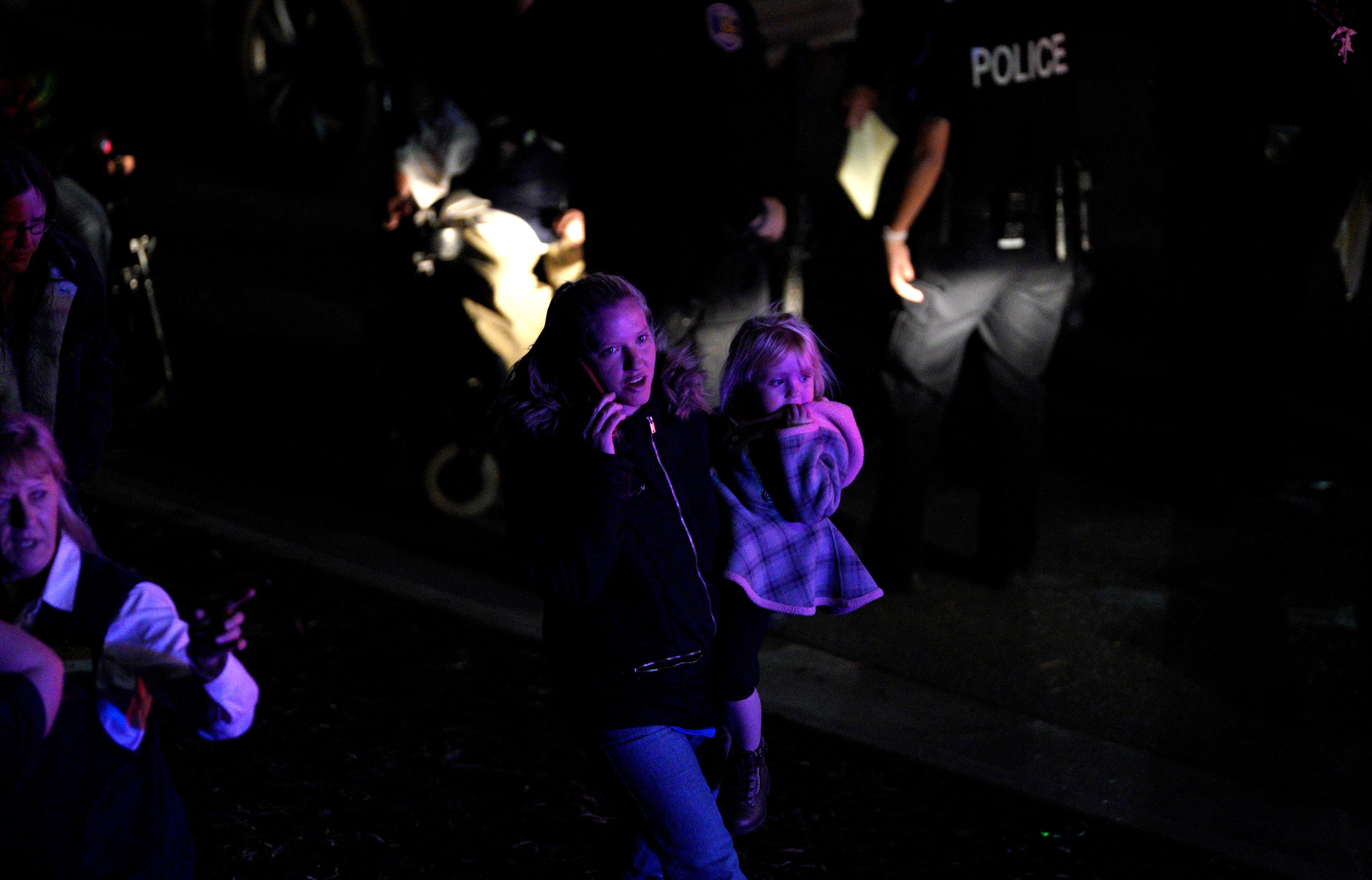 فتاة تحمل طفلة قرب موقع الحادث