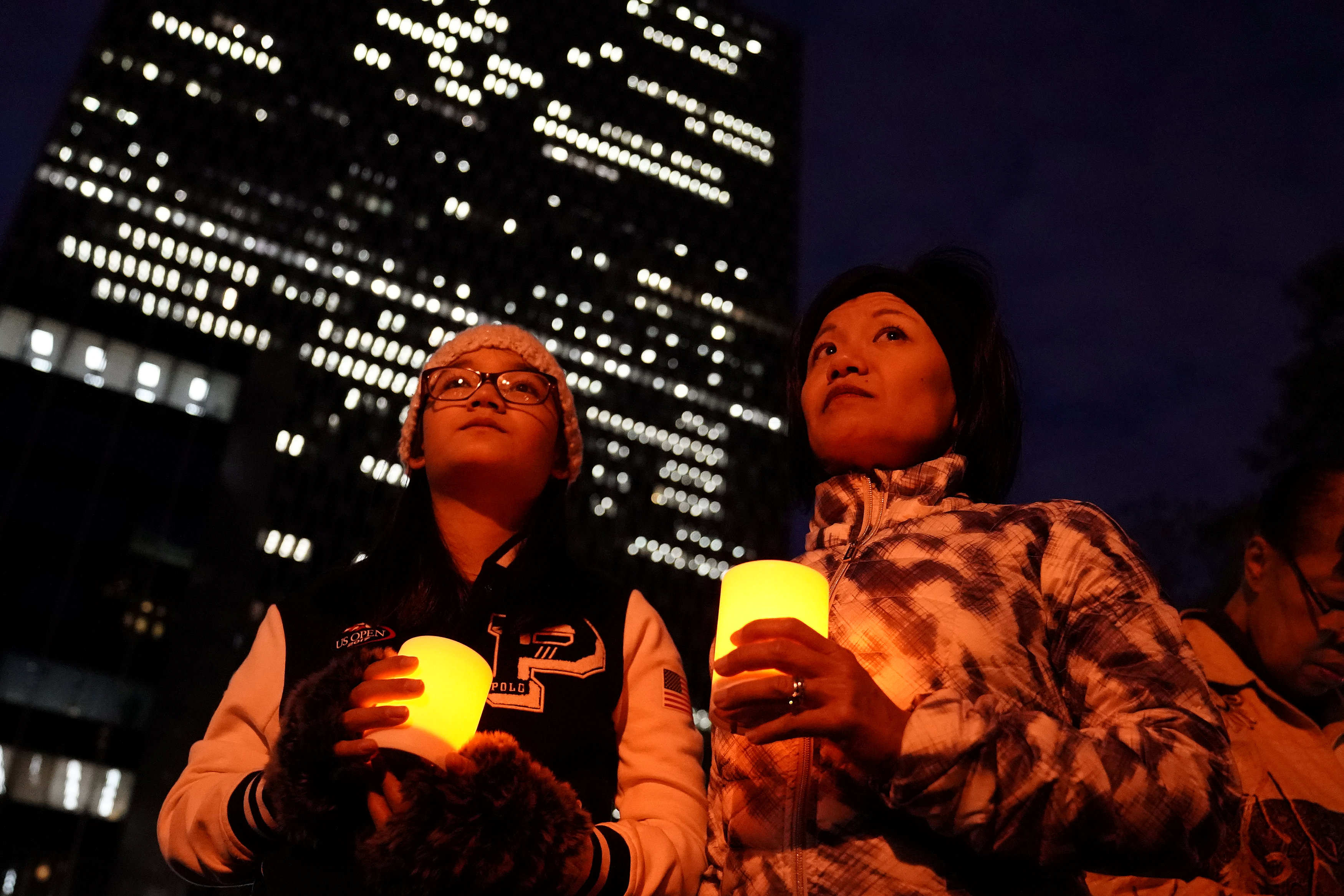 فتاتان تشاركان فى وقفة بالشموع لتأبين ضحايا حادث دهس نيويورك