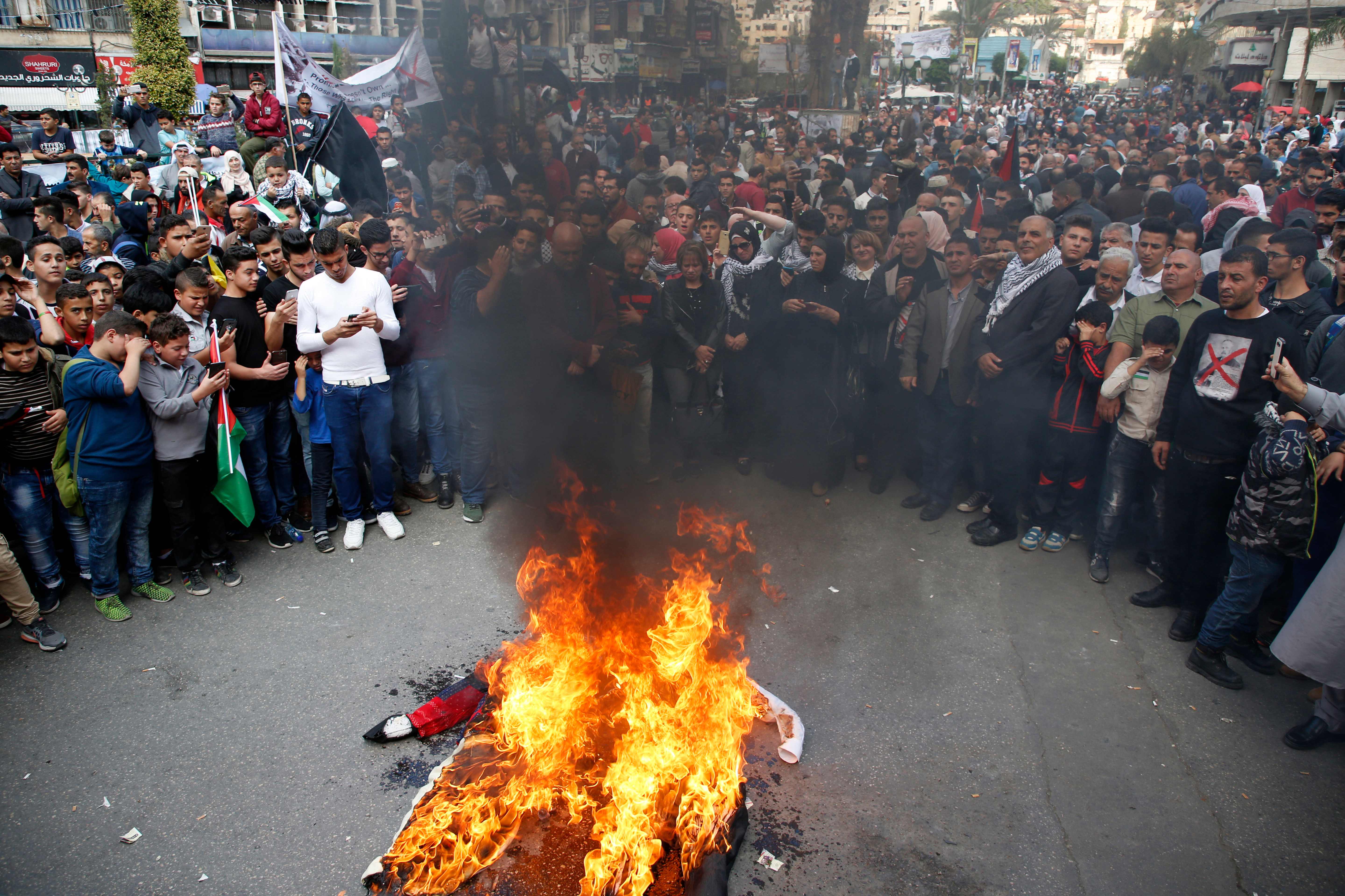 فلسطينيون يحرقون دمية رئيسة الوزراء البريطانية تيريزا ماى