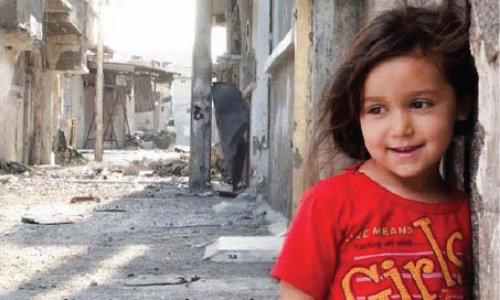 طفلة عراقية تبتسم وسط دمار الحرب