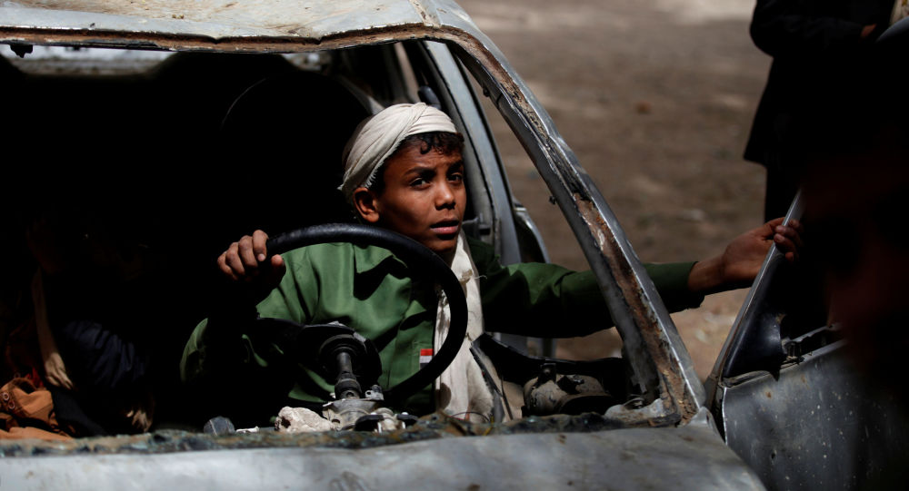 طفل يمنى يركب سيارة متفحمة جراء الحرب