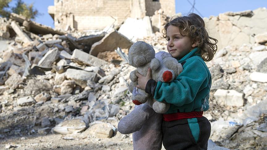 طفلة تحمل دميتها وسط ركام الحرب