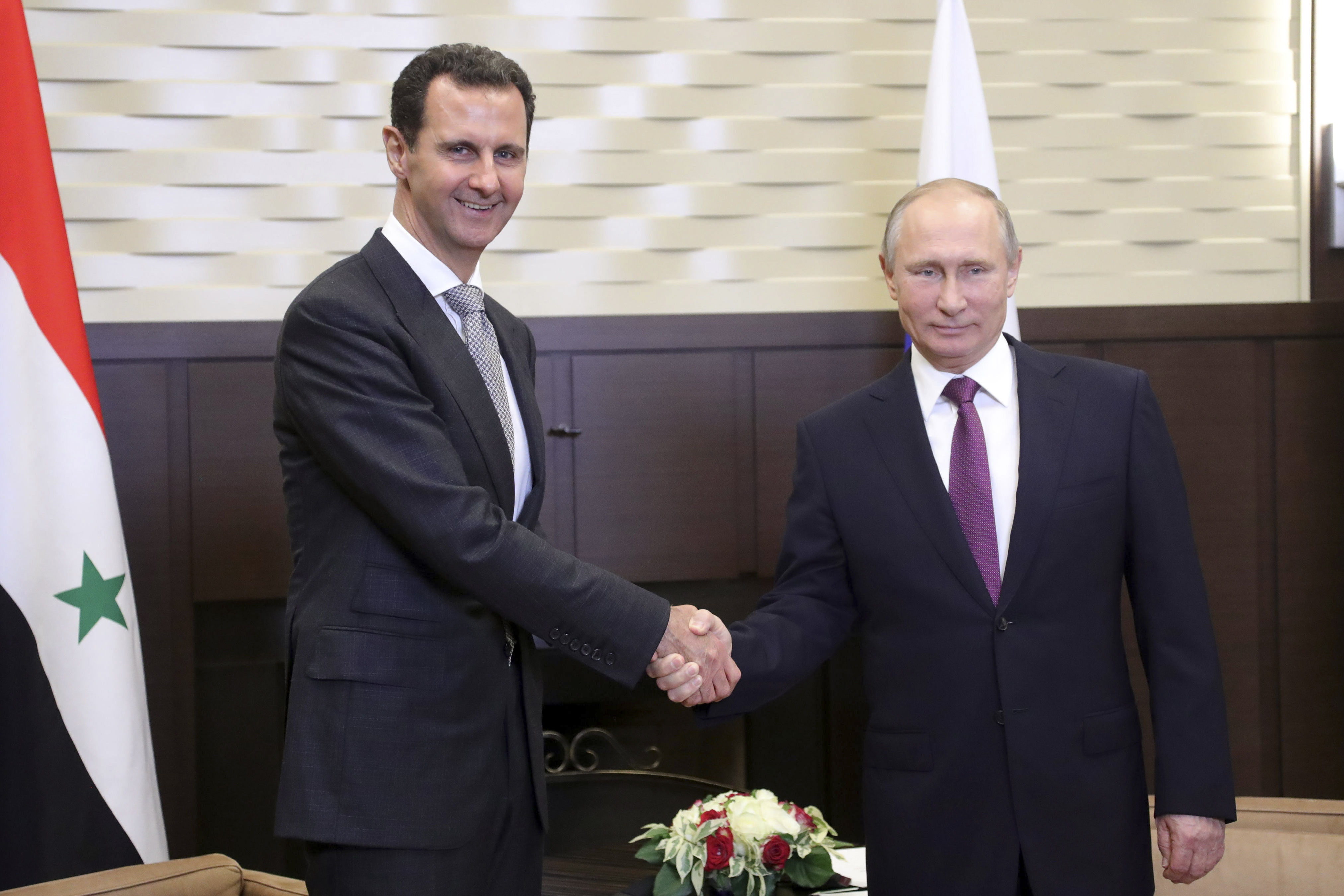 بشار الأسد يصافح فلاديمير بوتين خلال زيارته لروسيا