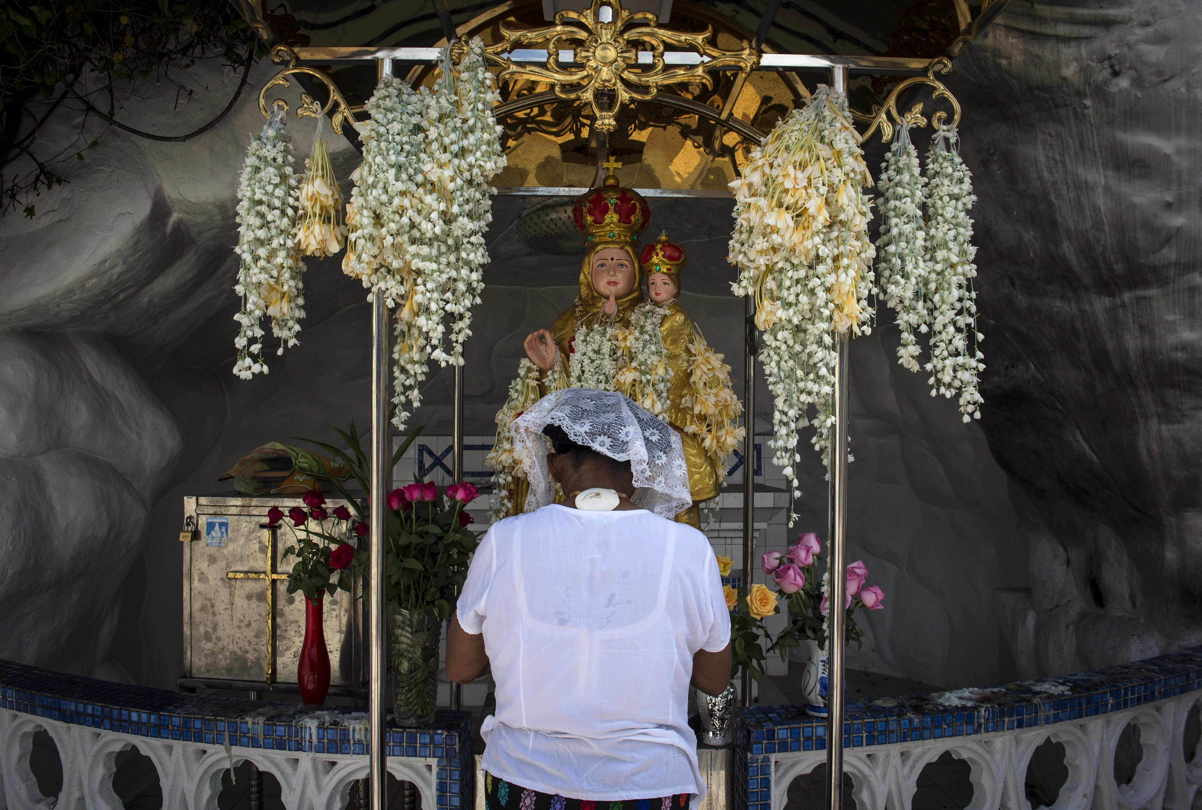 سيدة تصلى أمام تمثال مريم العذراء فى كنيسة القديس أنتونى