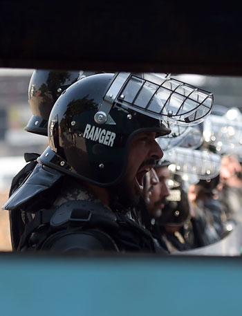 شرطى باكستانى يصرخ فى وجه متظاهرين متشددين