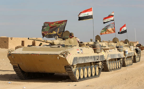 القوات العراقية تحمل علم البلاد وشارات لبيك "يا حسين"