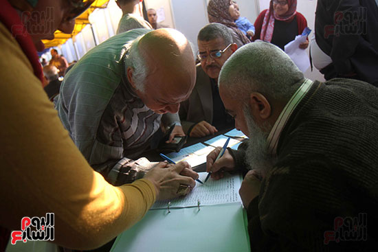 موظف يساعد أحد الاعضاء كبار السن فى التصويت بانتخابات مركز شباب الجزيرة 