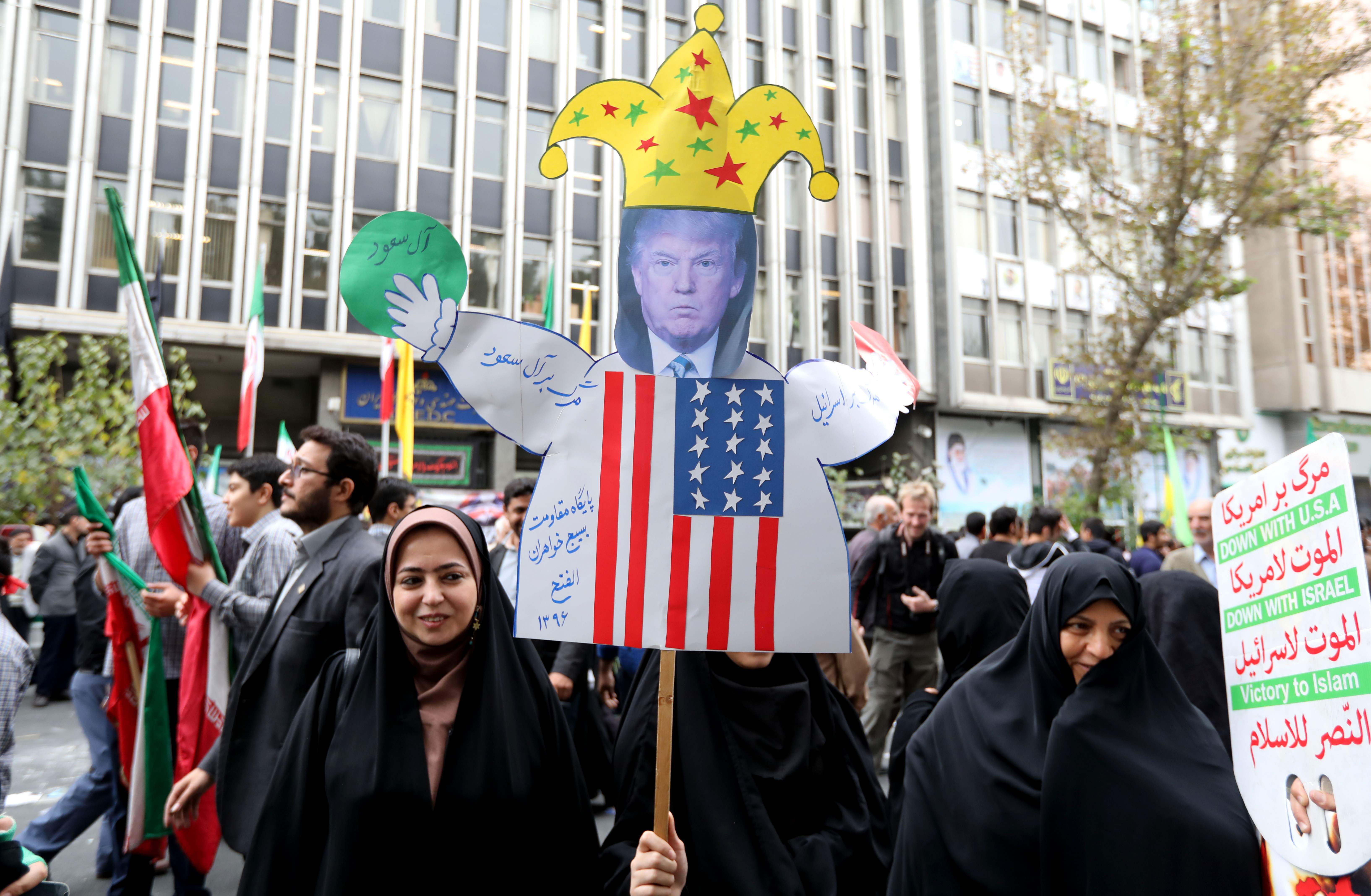 مواطنة إيرانية تحمل صورة ساخرة لترامب
