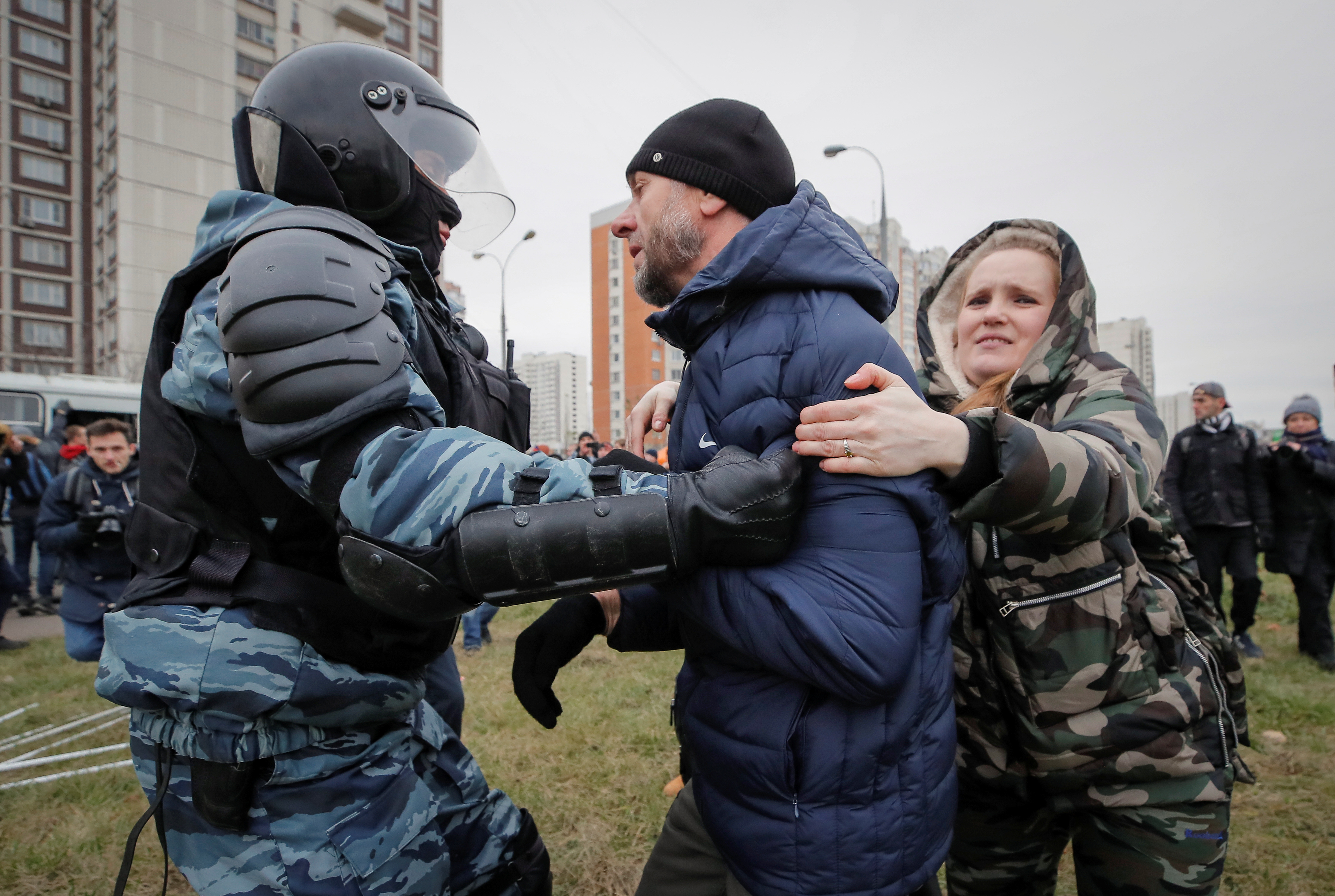 متظاهرة تحاول تحرير شخص من يد الشرطة الروسية