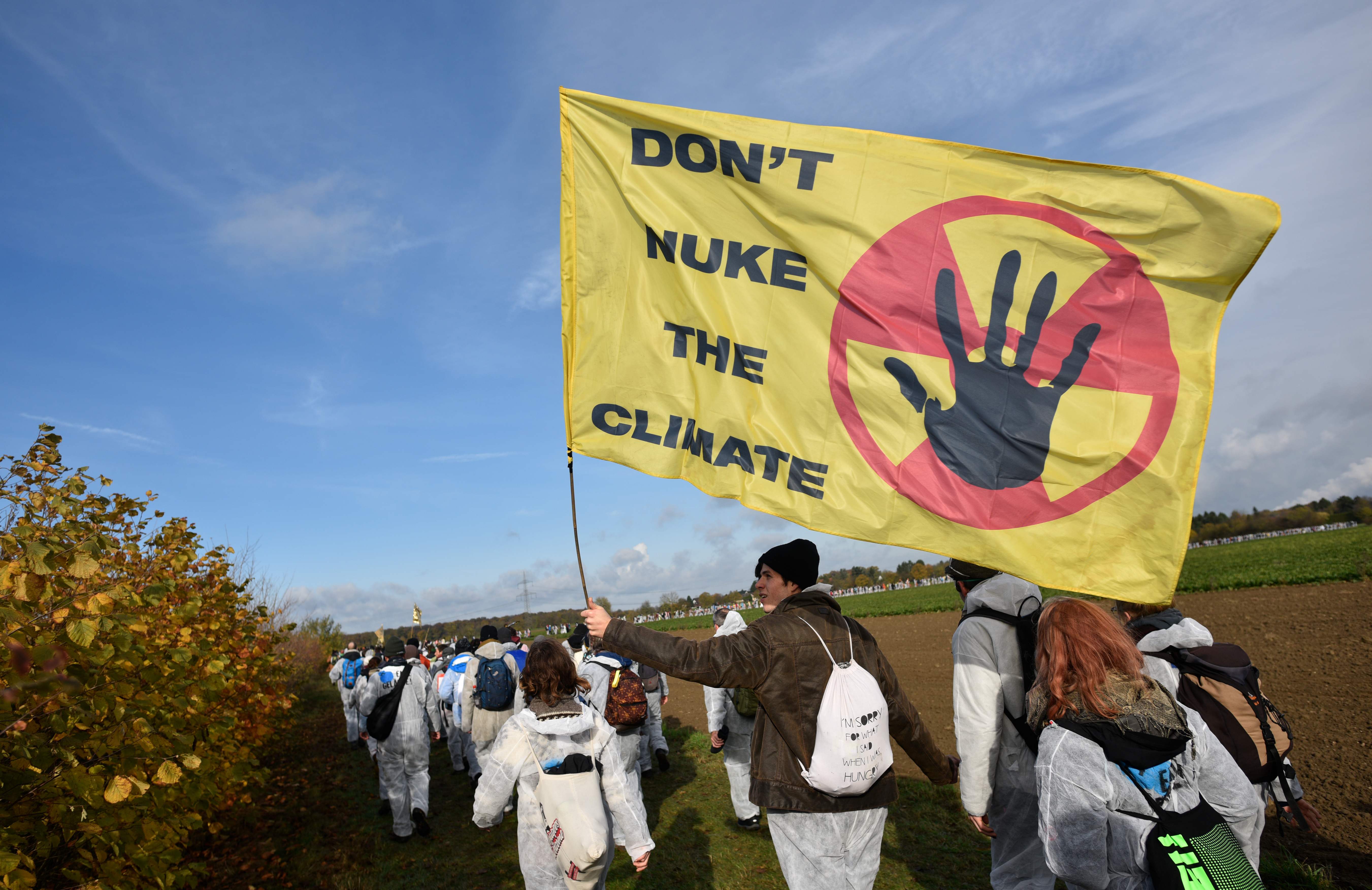 متظاهرون يرفعون لافتات تؤيد اتفاقية تغير المناخ