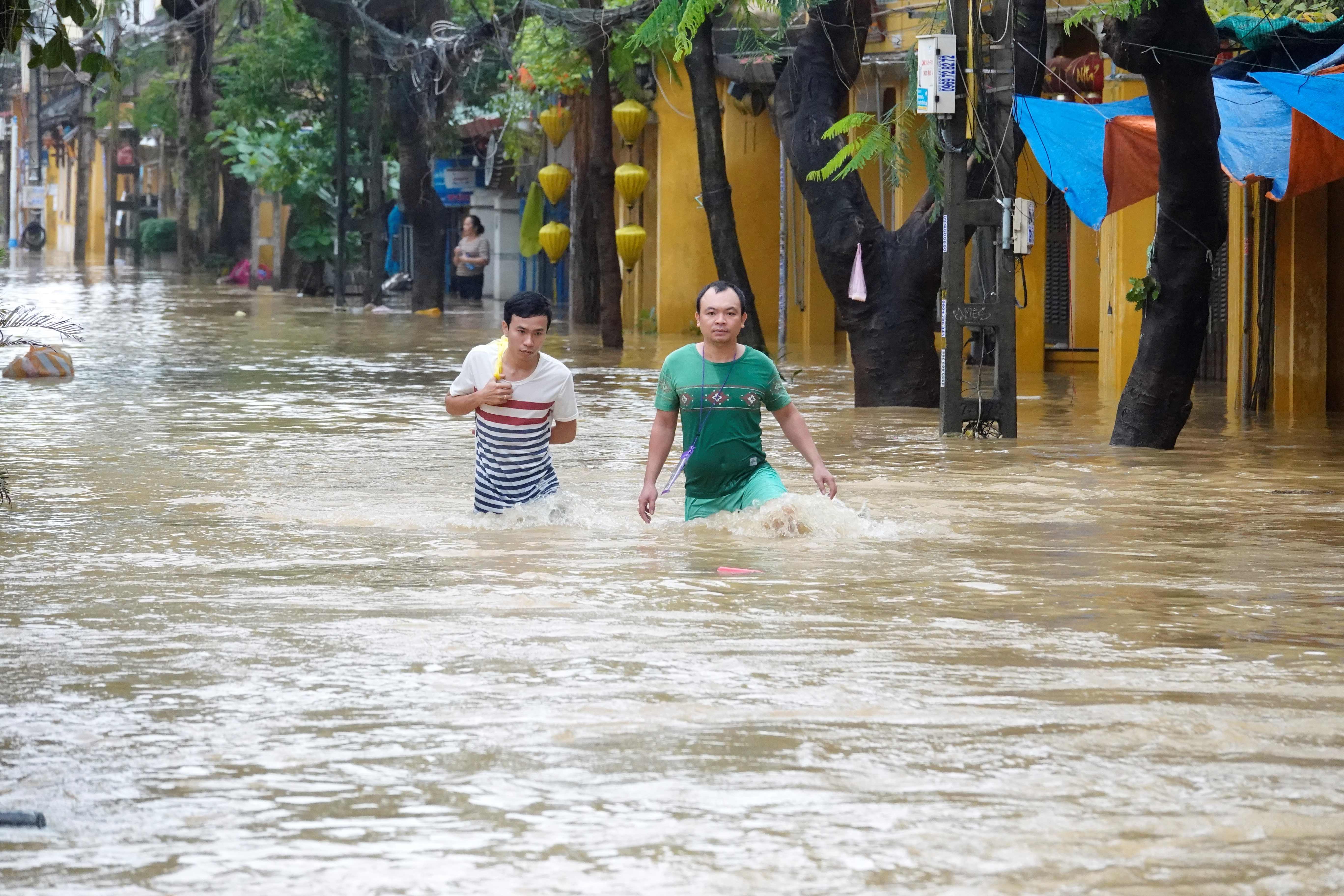 رجل يسير وسط مياه الفيضانات
