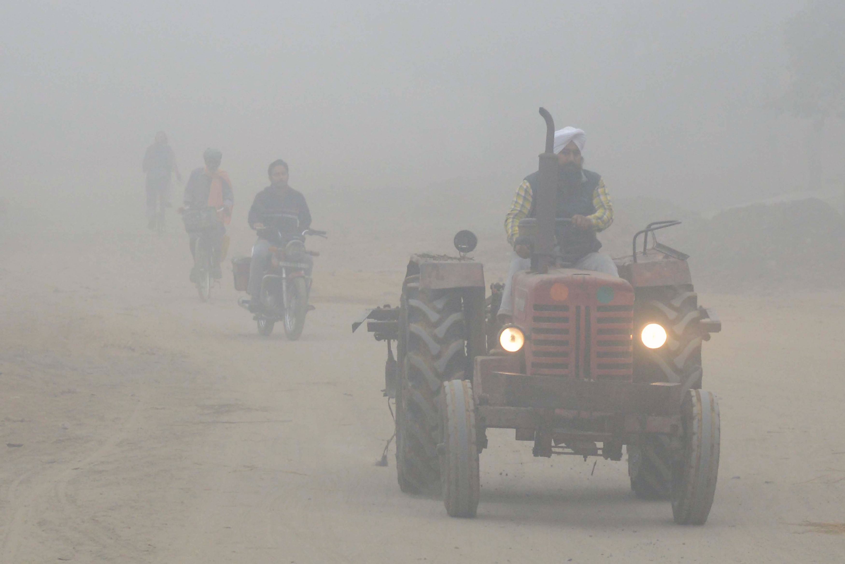مواطن هندى يقود جرار زراعى وسط الضباب الدخانى