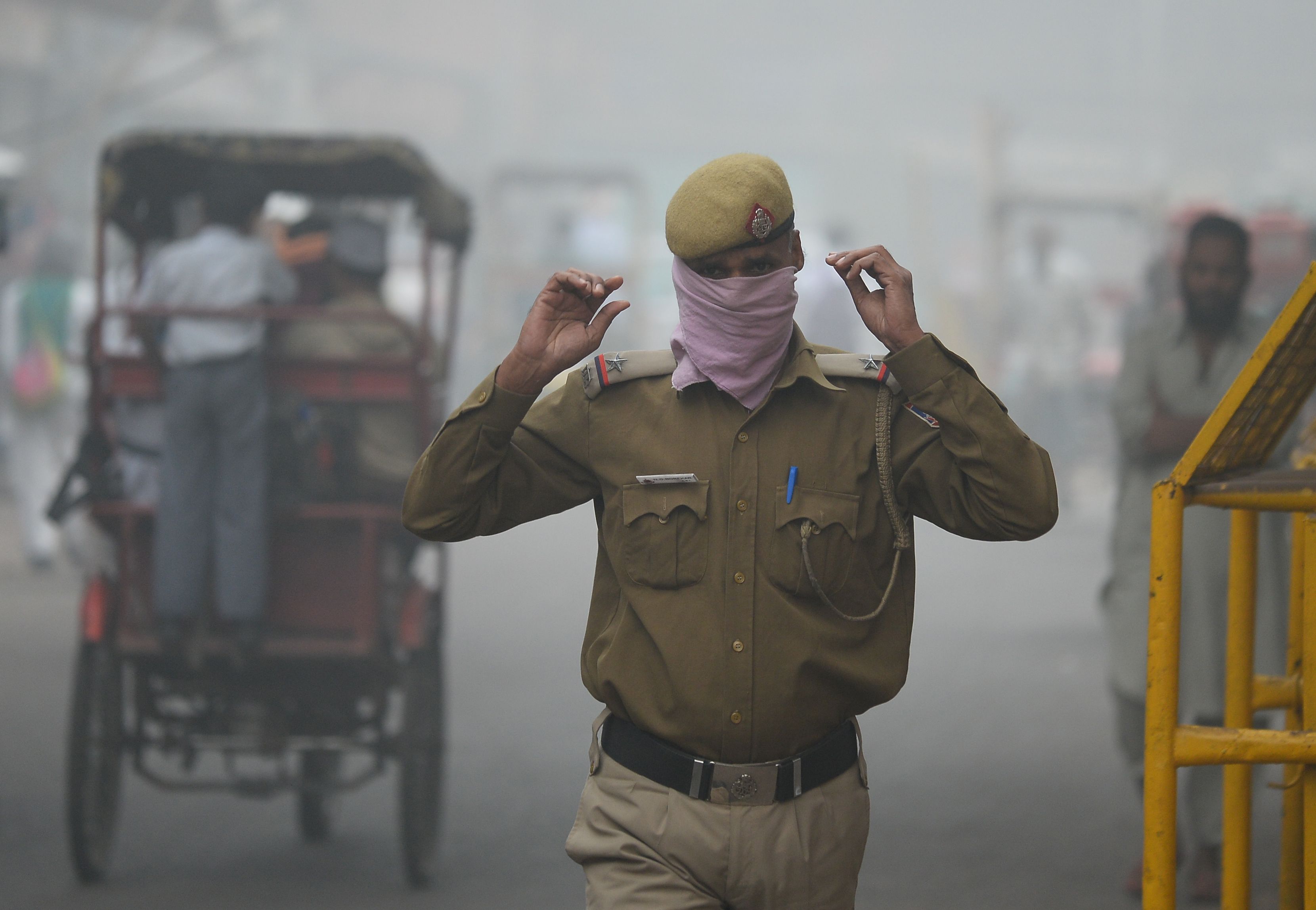 شرطى هندى يسير وسط الدخان