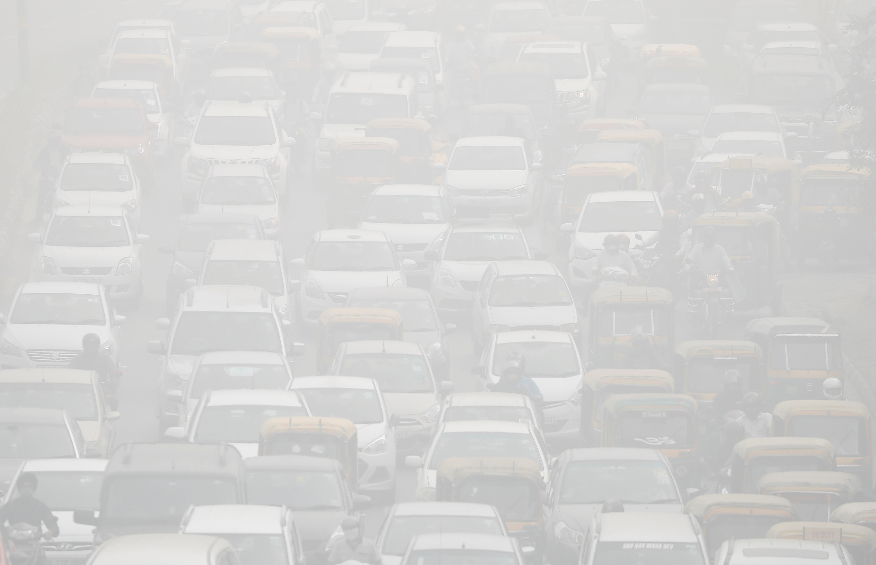 الدخان يغطى السيارات فى أحد الطرق الهندية