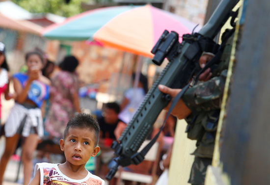 طفل-ينظر-إلى-جندى-برازيلى