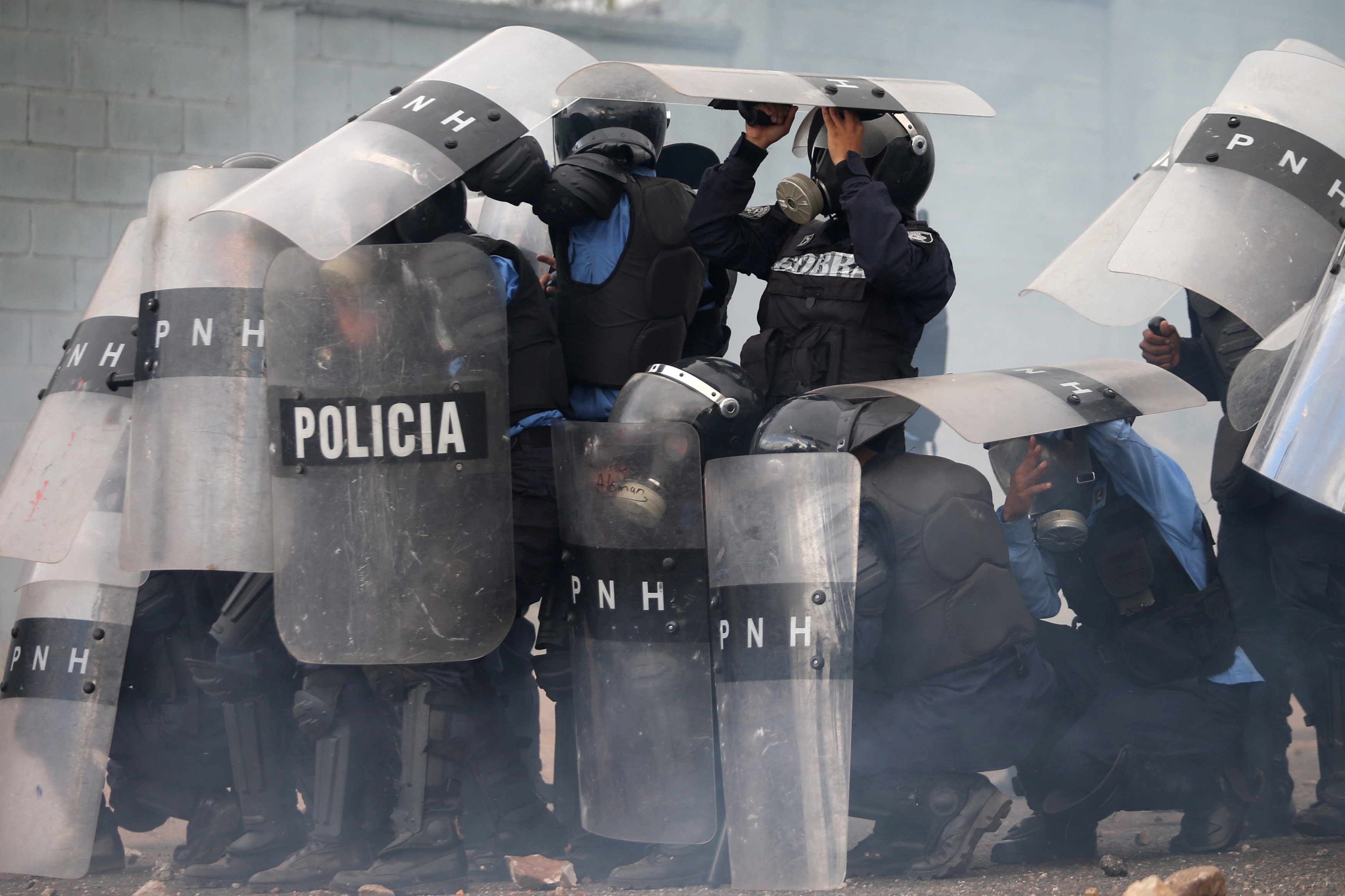 قوات الأمن فى هندوراس تختبئ من حجارة المحتجين