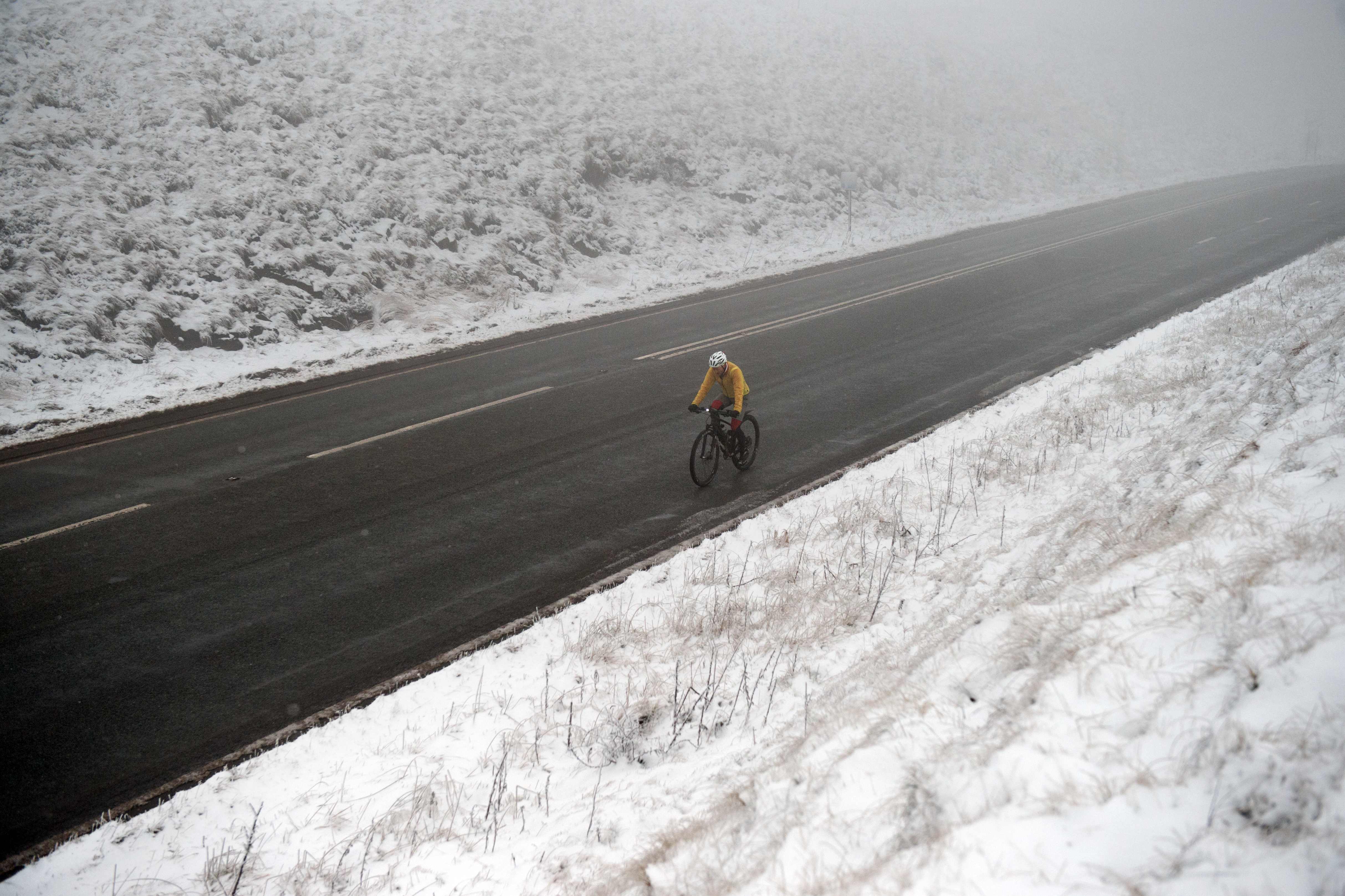 أحد المواطنين يقود دراجته وسط الثلوج