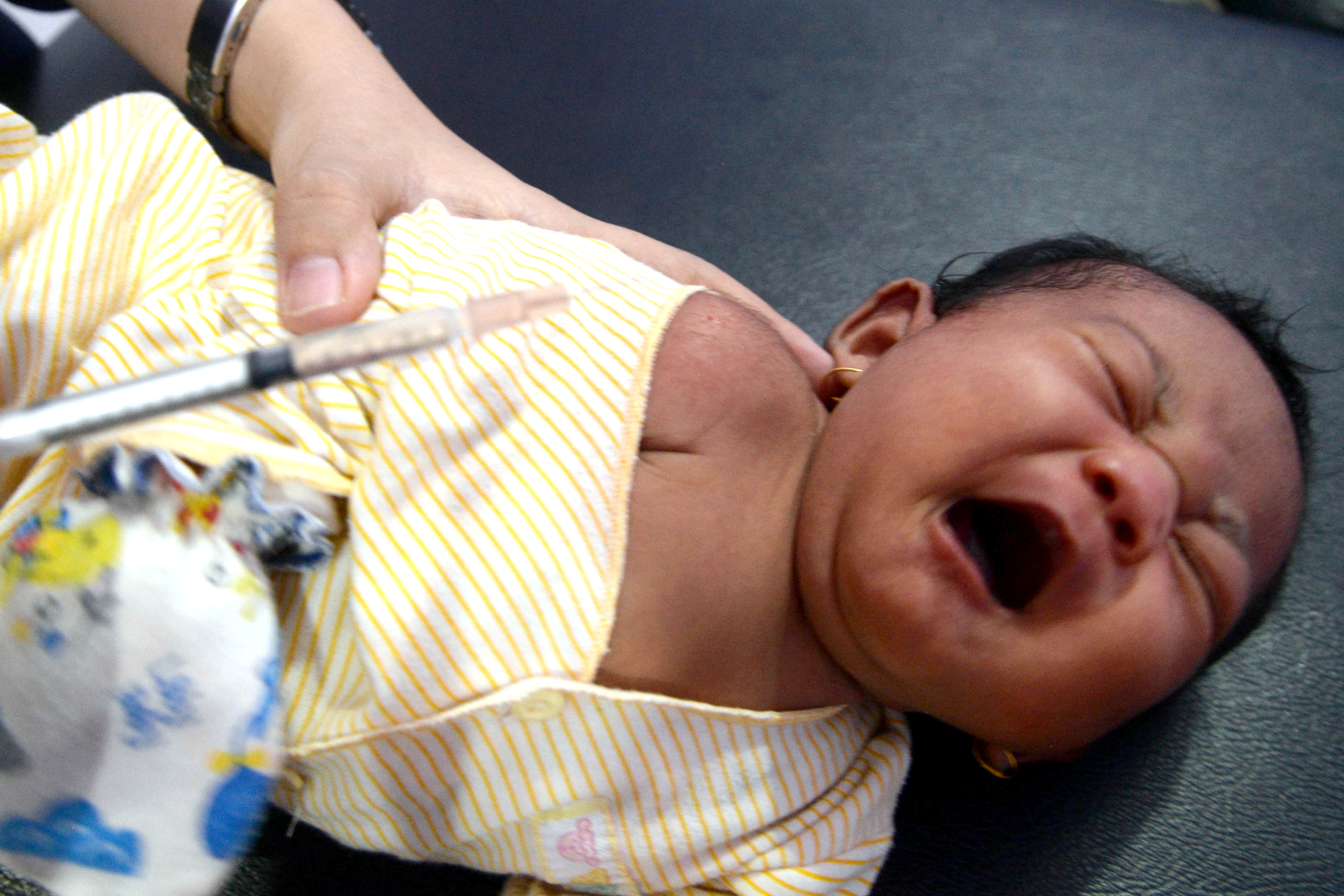رضيع يأخذ تطعيم  ضد مرض الدفتيريا فى إندونيسيا