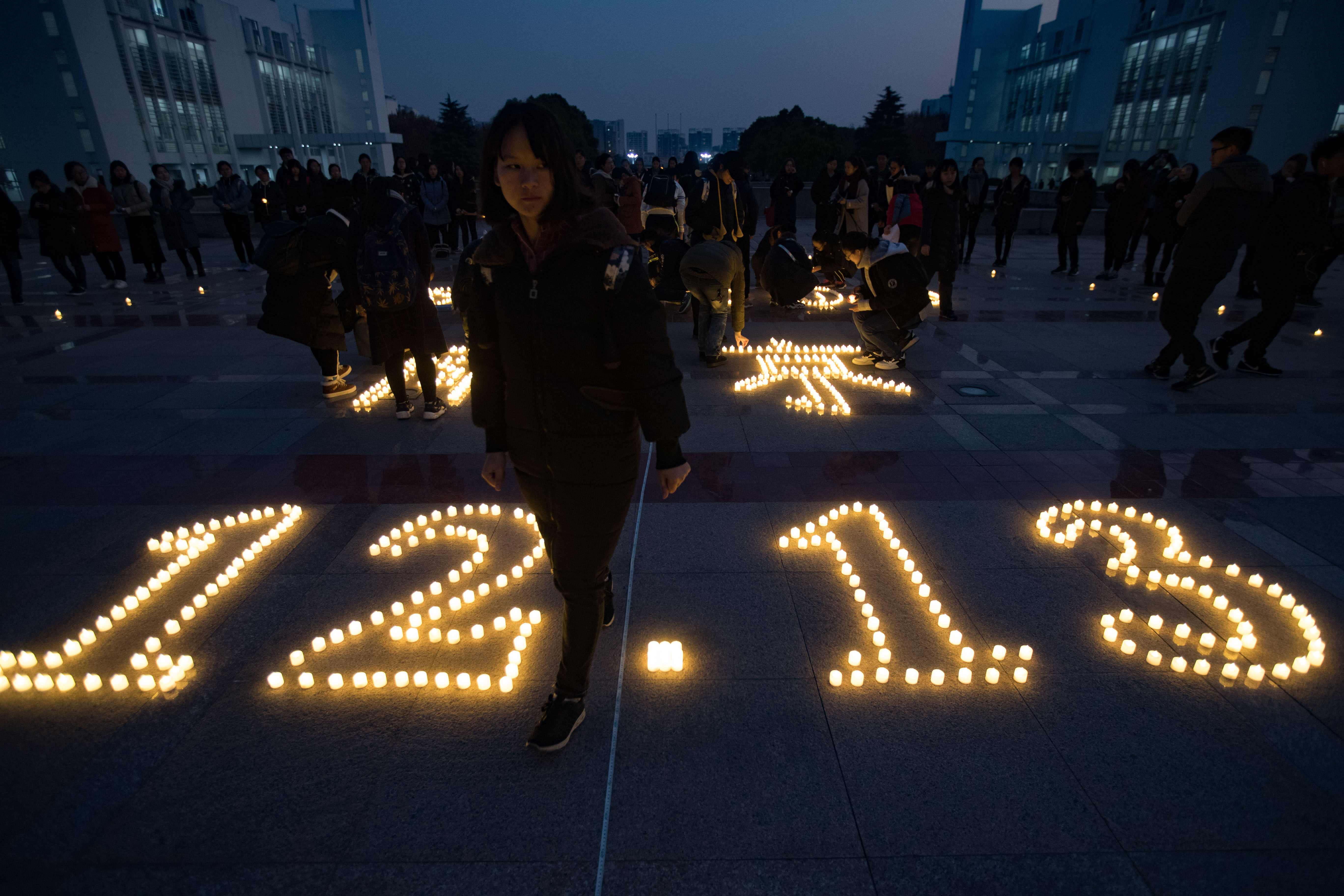 طلاب يحيون ذكرى مذبحة نانجينج بالشموع