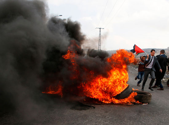 شاب فلسطينى يواجه رصاص الاحتلال بالحجارة