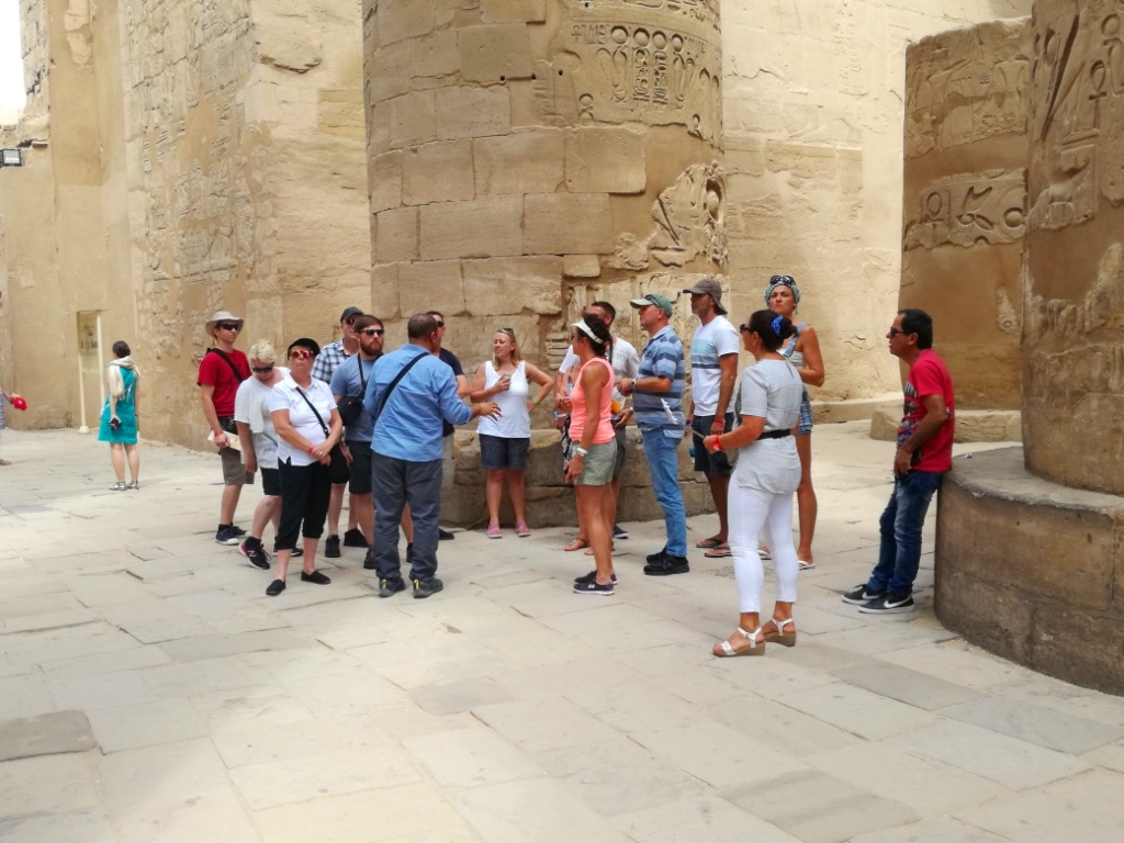 مرشد سياحي يشرح تاريخ معابد الكرنك لفوج سياحي
