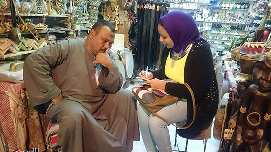 أحد أصحاب بازارات السوق السياحى مع محررة اليوم السابع