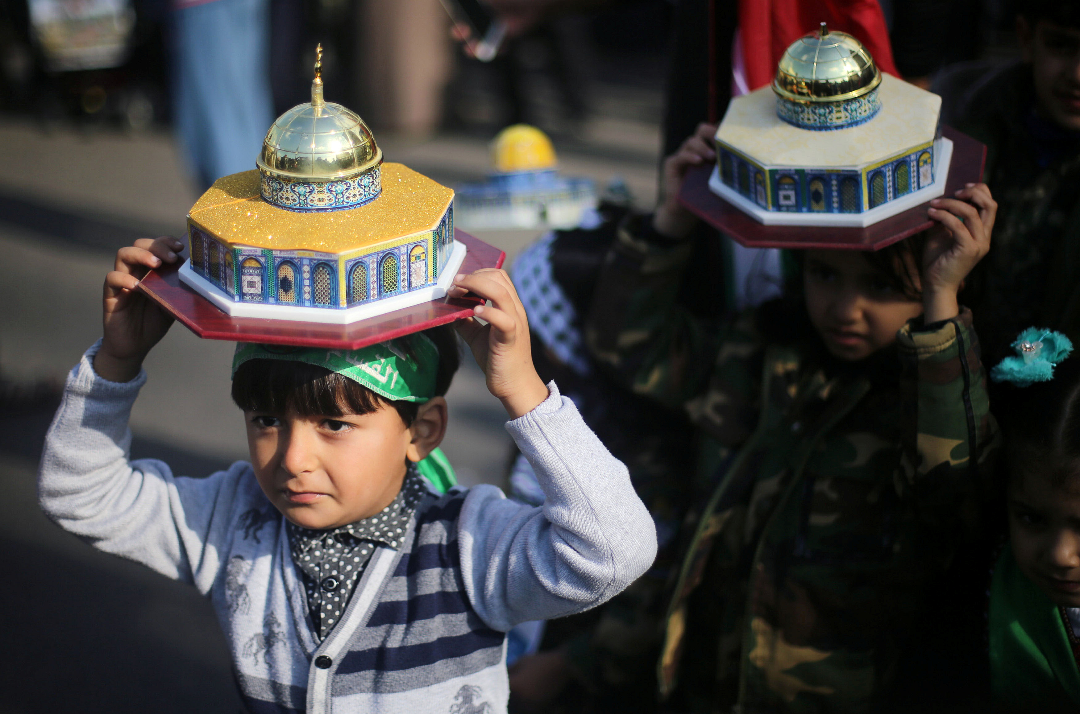 أطفال فلسطينيين يحملون مجسم للأقصى على رأسهم