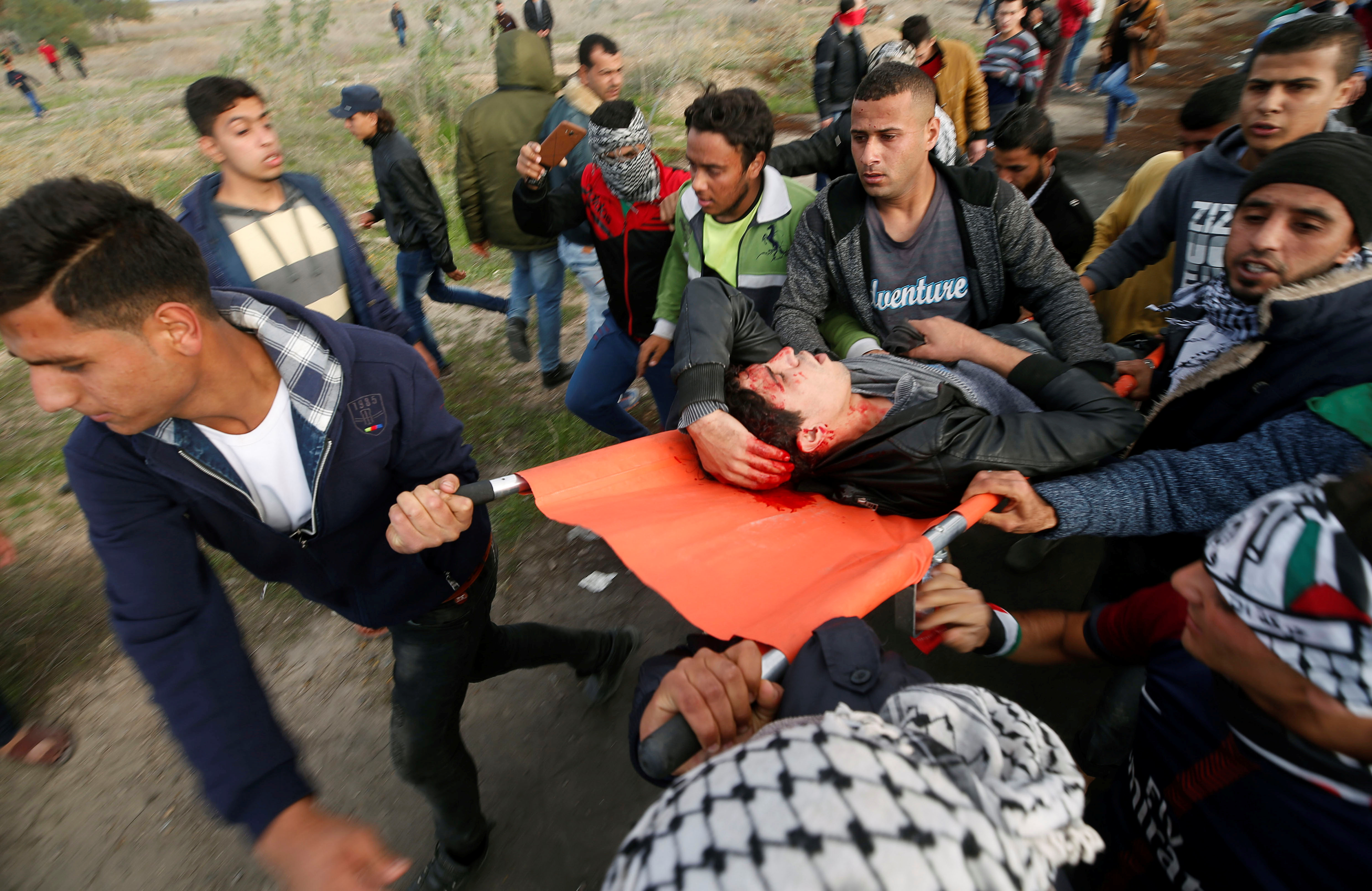 فلسطينيون يحمل شاب مصاب خلال مواجهة قوات الاحتلال