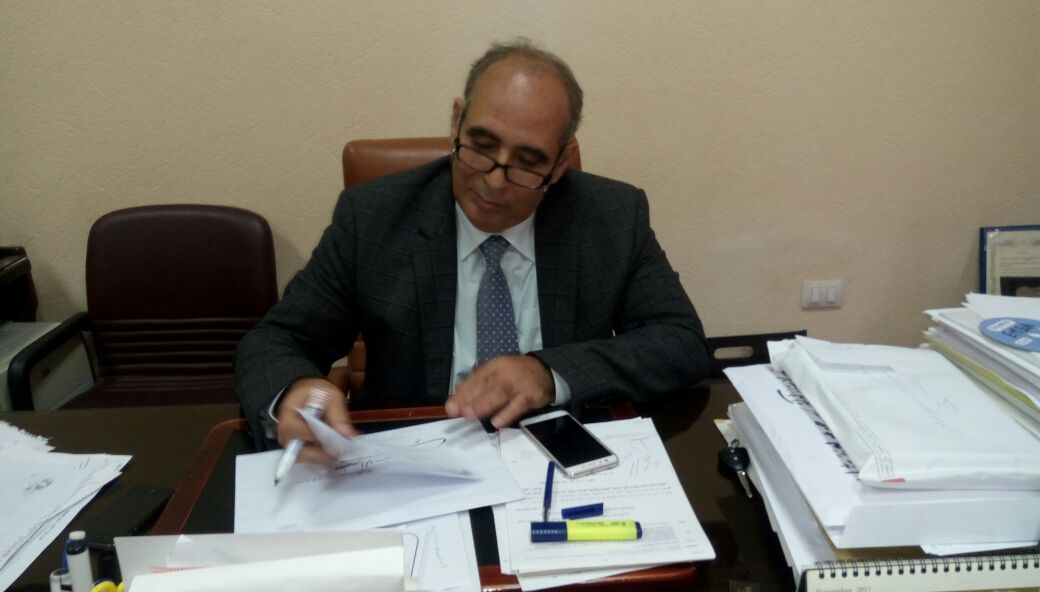 الدكتور سعيد عبدالعزيز يطالع أوراق بمكتبه