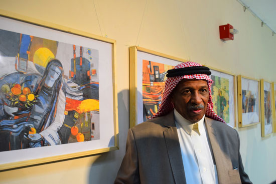  الفنان سمير الدهام خلال شرح لوحاته بالمعرض