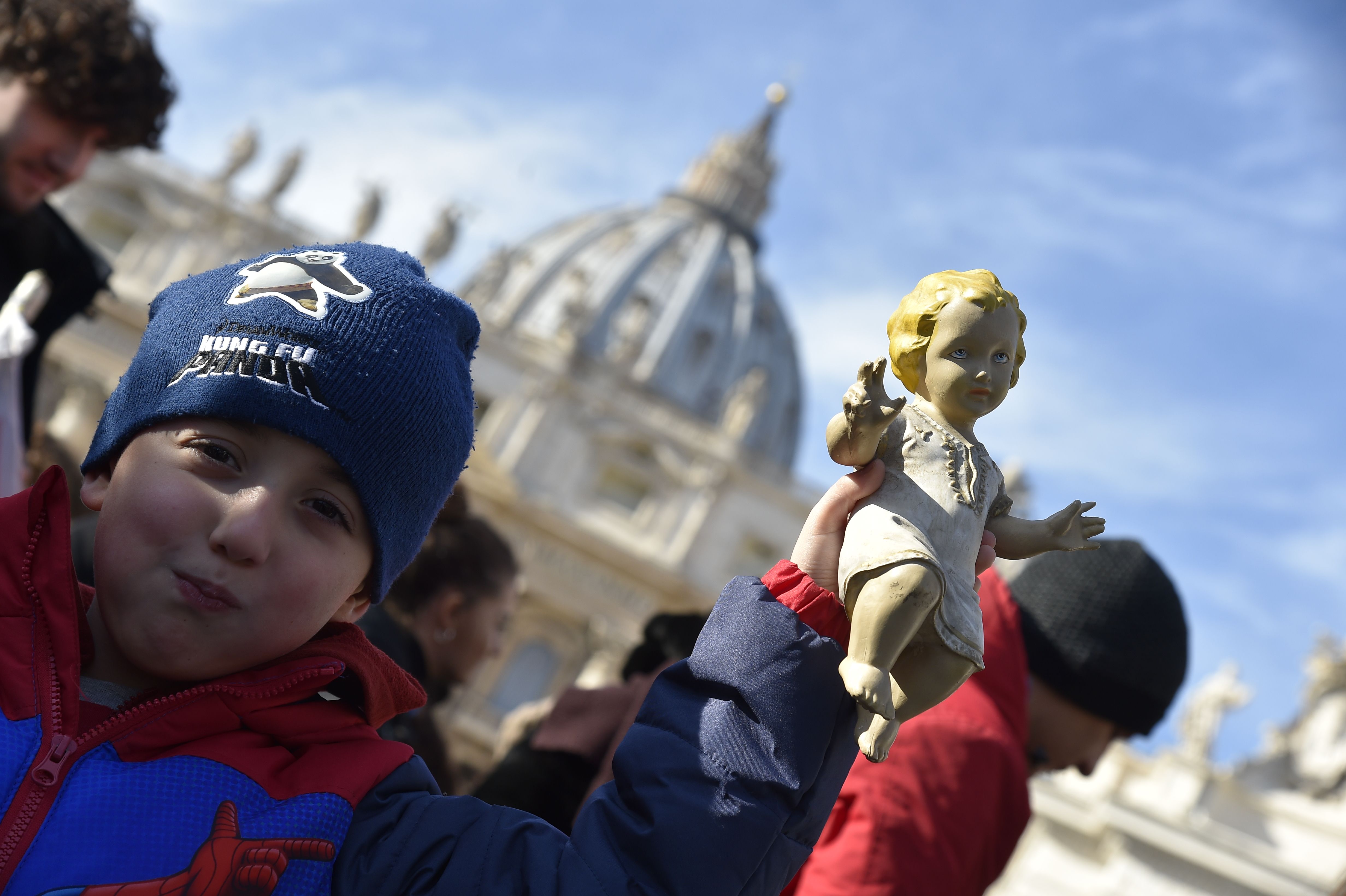 طفل يحمل تمثال ليسوع 