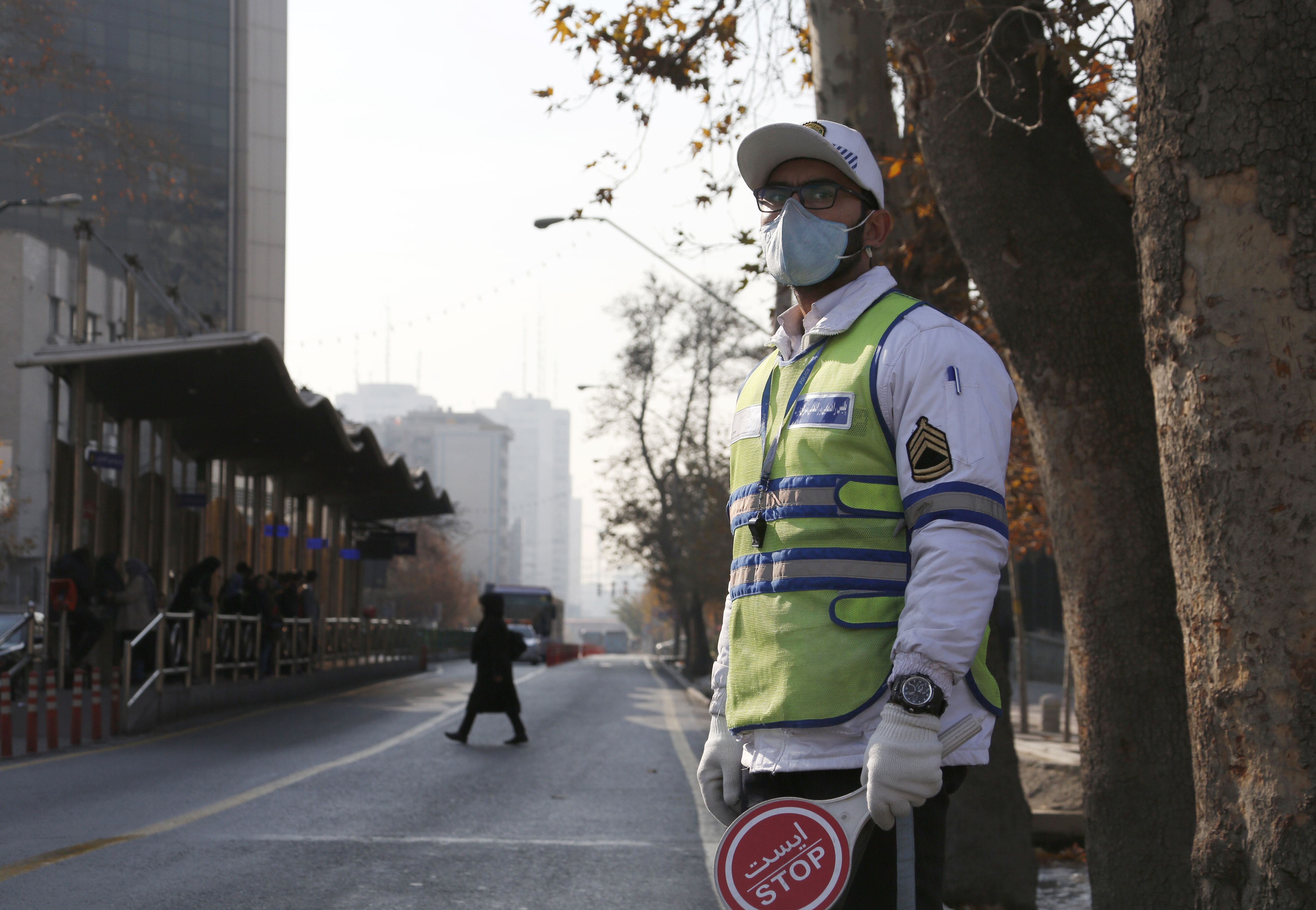 رجل مرور فى إيران ينظم حركة السير فى ظل التلوث