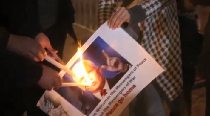 محتجون يحرقون صورة بنس