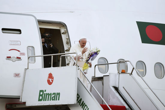 بابا الفاتيكان يحمل باقة ورد أثناء مغادرته بنجلادش