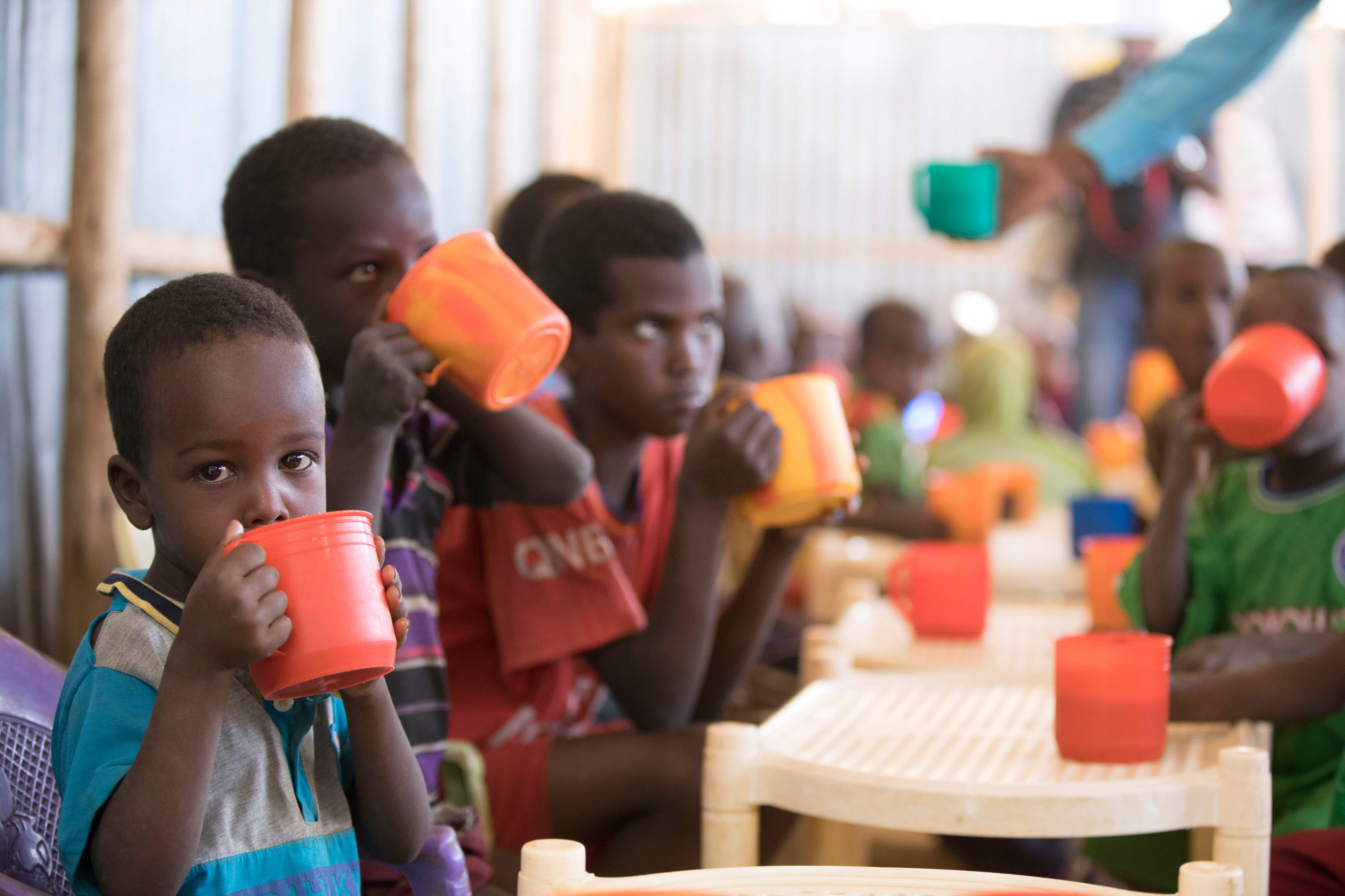 أطفال صوماليون يشربون داخل أحد المخيمات