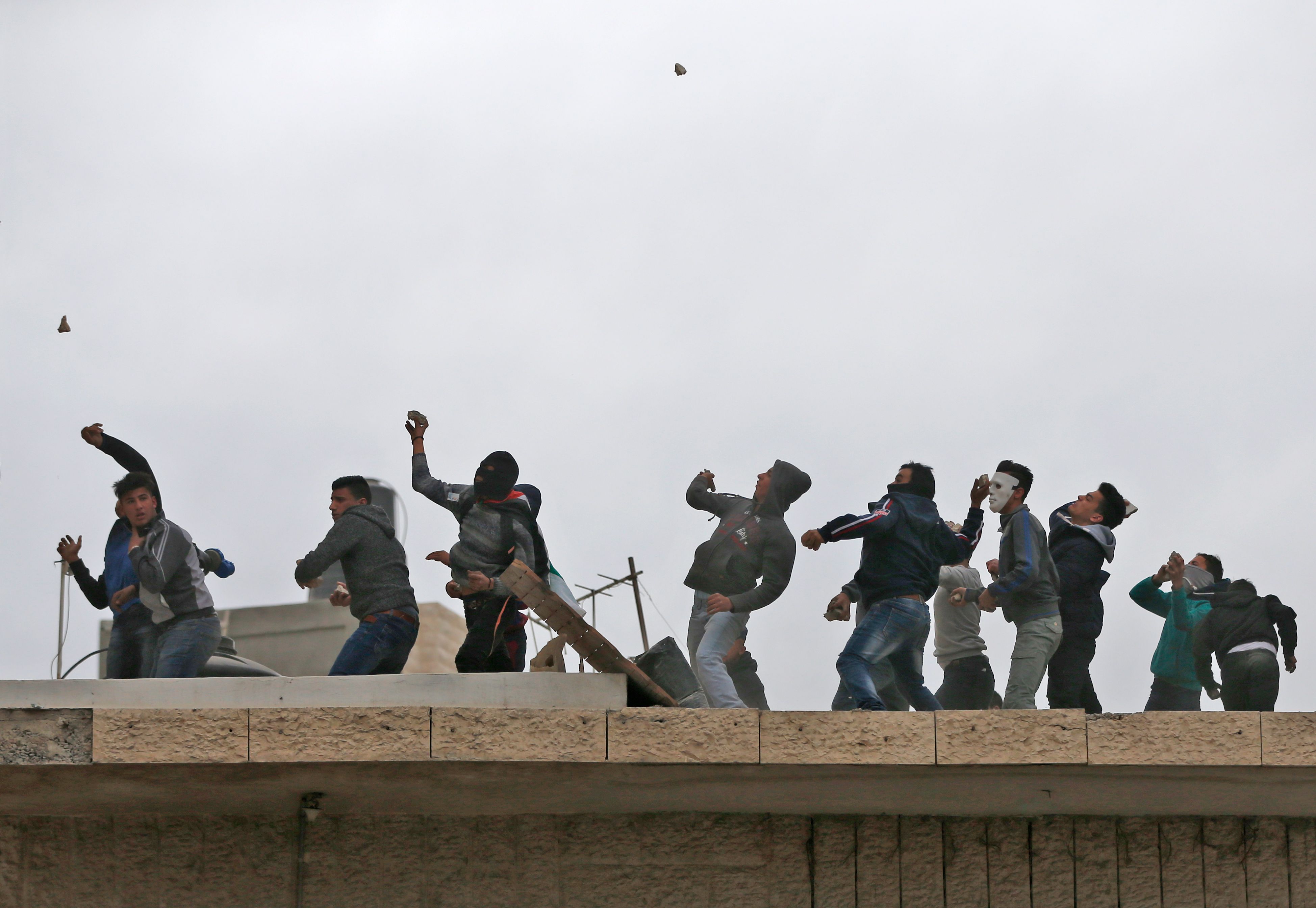 الشبان الفلسطينيين يقذفون الاحتلال بالحجارة