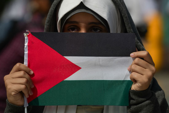 متظاهرة ماليزية تحمل علم فلسطين